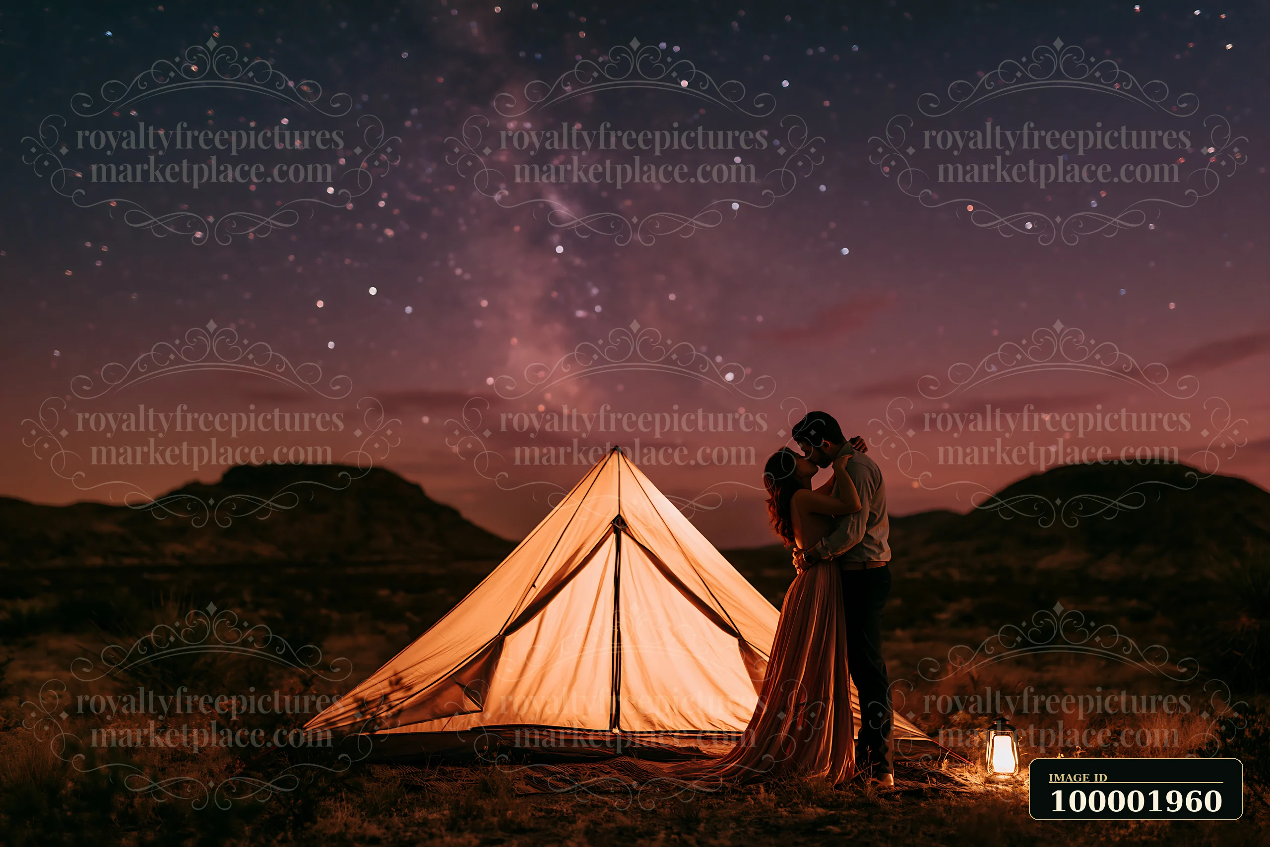 A couple kissing under a starry sky stands close to a tent in a remote area at night.