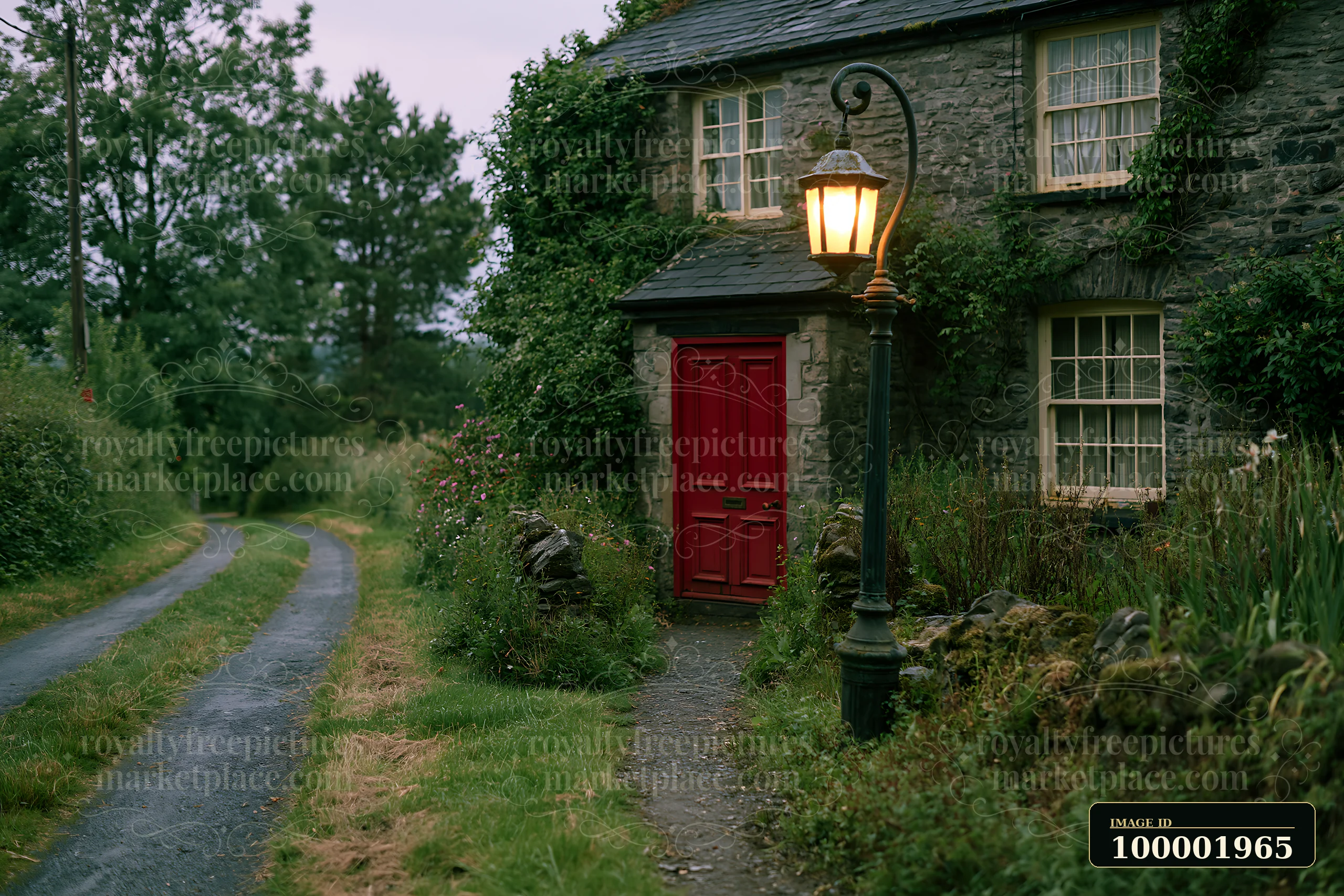 A cottage beside country lane features a red door and a street lamp.