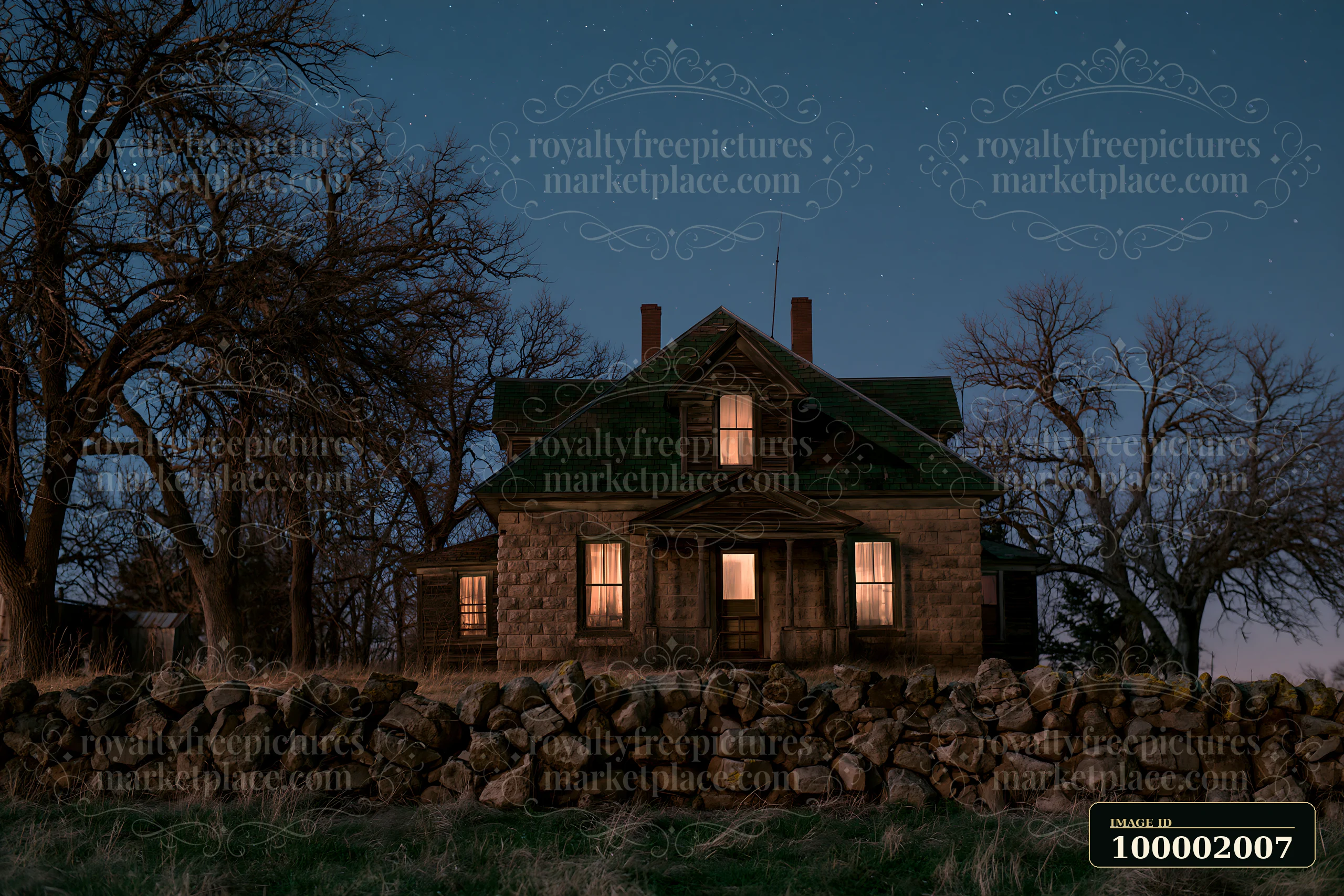A country house stands in a rural setting at night, with warm lights glowing from the windows.