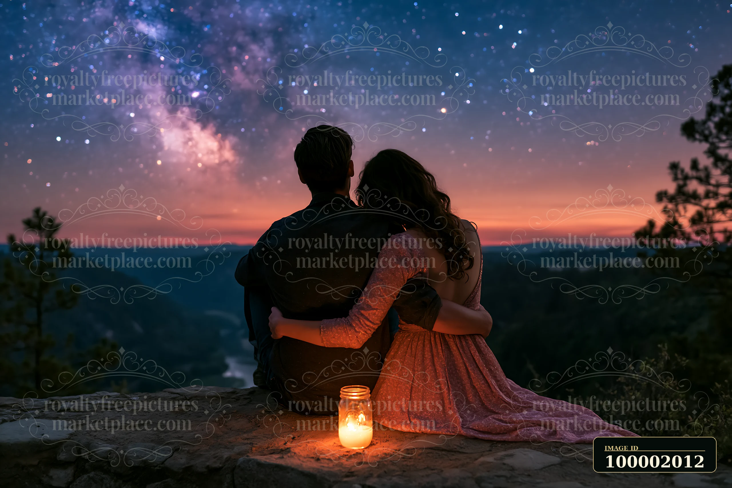 A romantic couple under the Milky Way sits on a rocky ledge.
