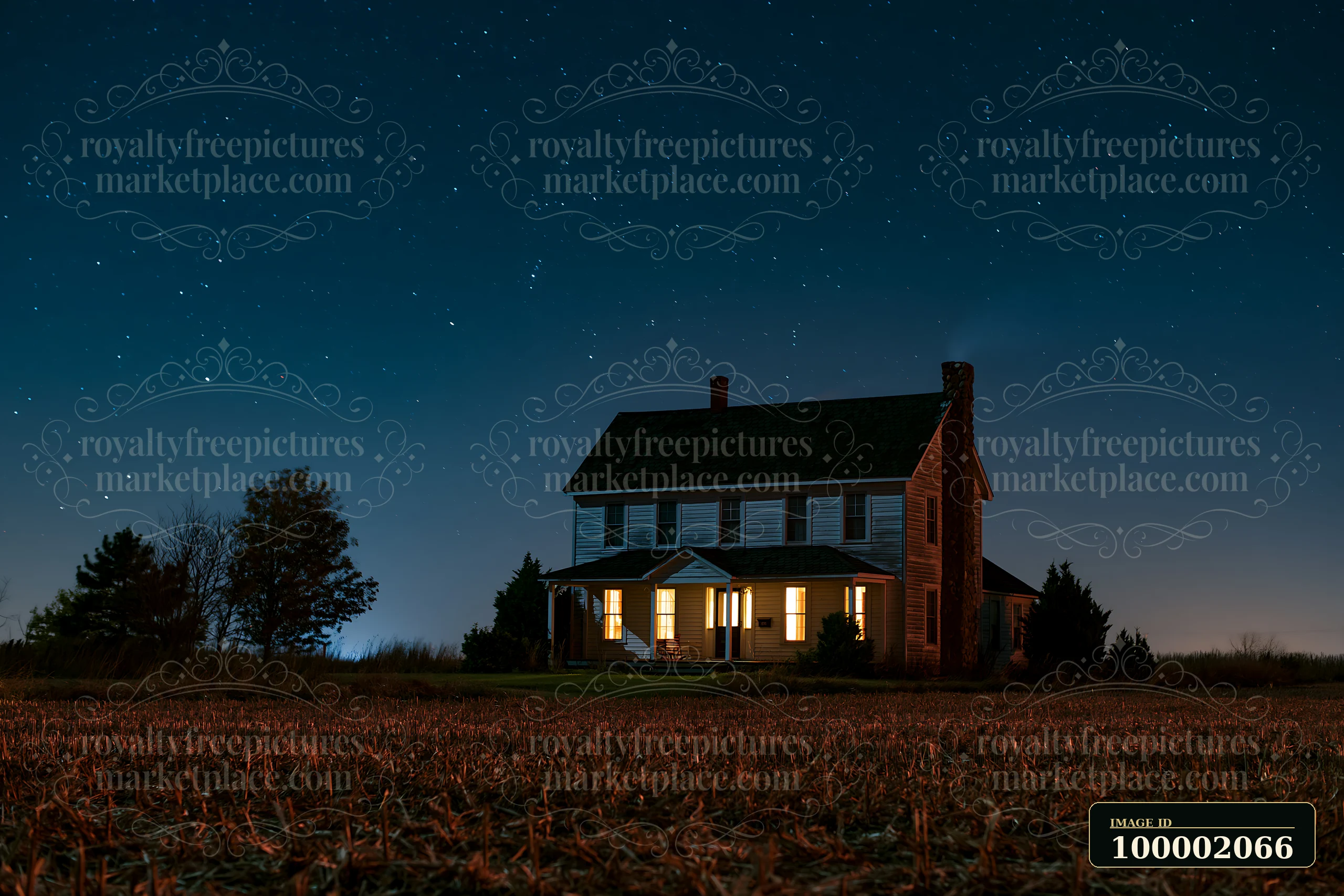 A country house stands under a starry sky with lights shining from its windows.