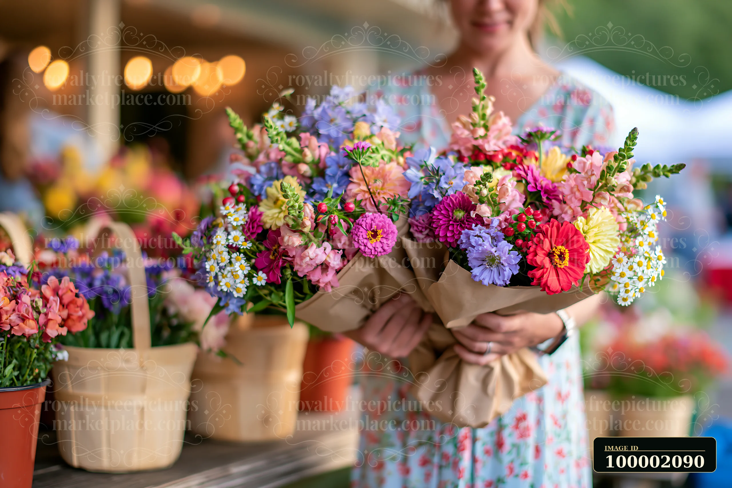 Colorful bouquets of mixed seasonal flowers are held by a person at a farmers market.