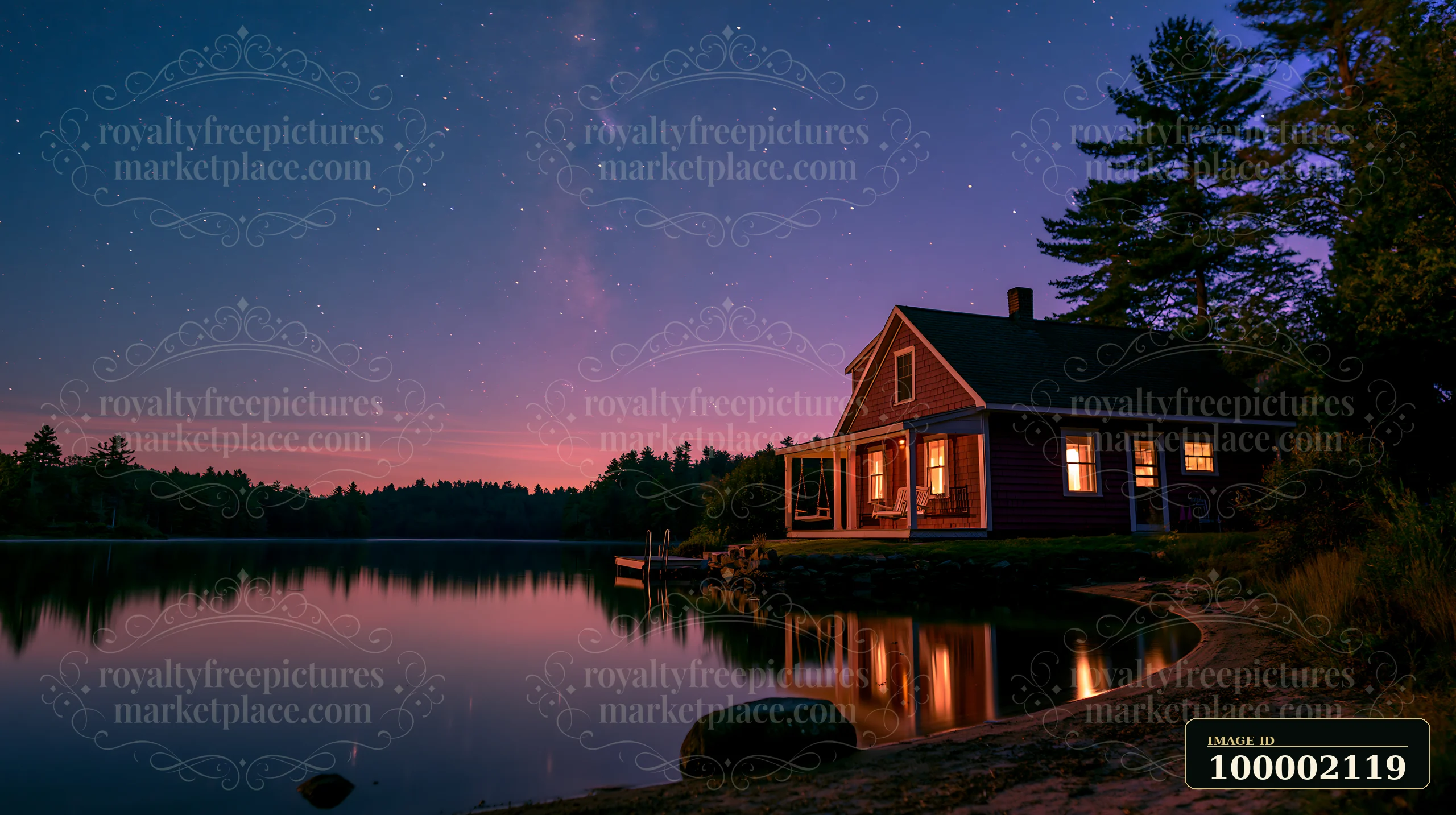 A house features a porch swing under a starry sky near a lake.