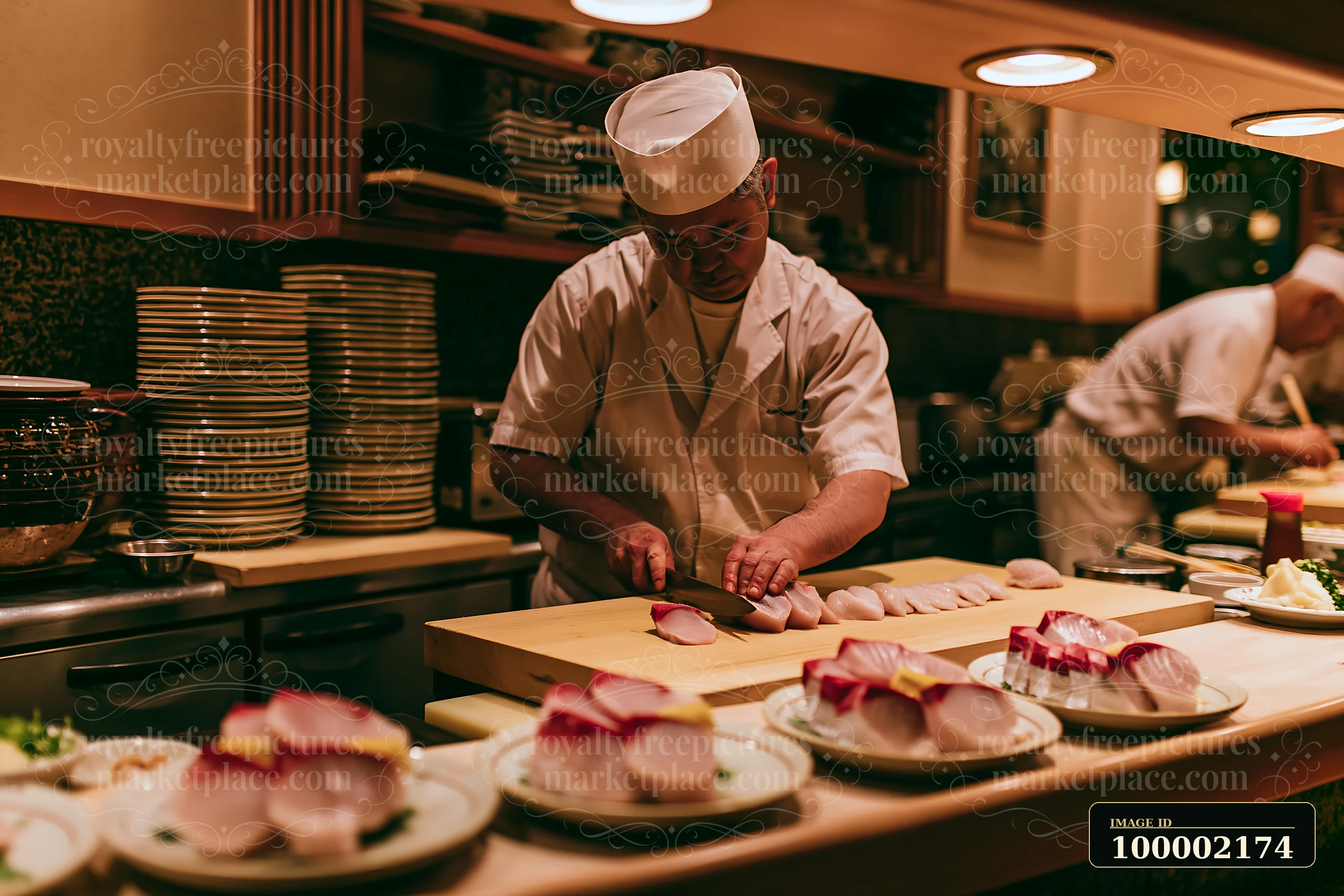 A chef is slicing sushi at a counter in a restaurant kitchen, with neatly arranged plates of sushi in front.