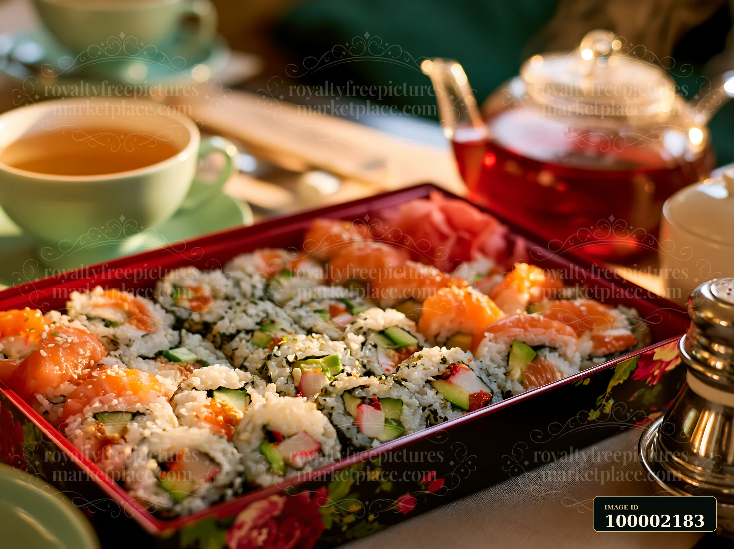 Sushi delivery box close-up shows various sushi rolls alongside a cup of tea and a teapot.