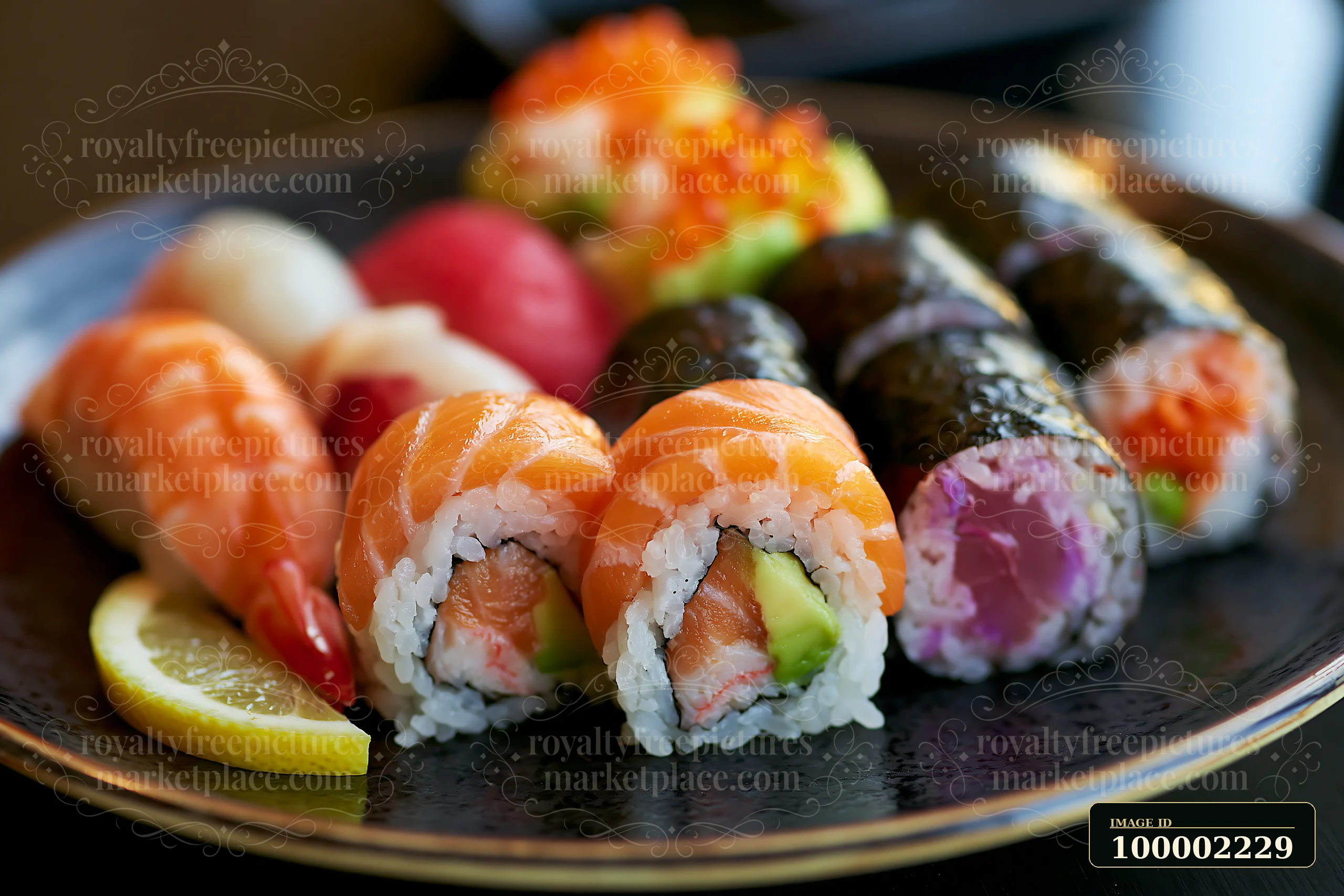 Sushi with lemon garnish close-up shows various types of sushi arranged on a black plate.
