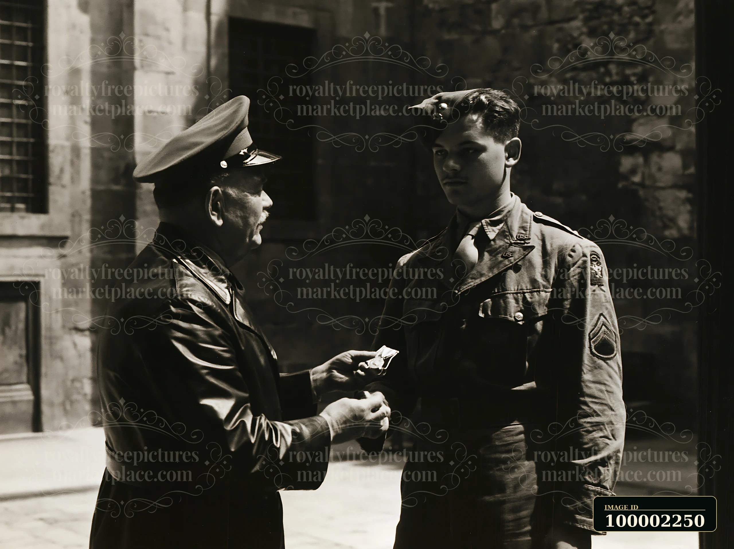 A soldier receiving medal stands attentively as a superior officer presents an award.