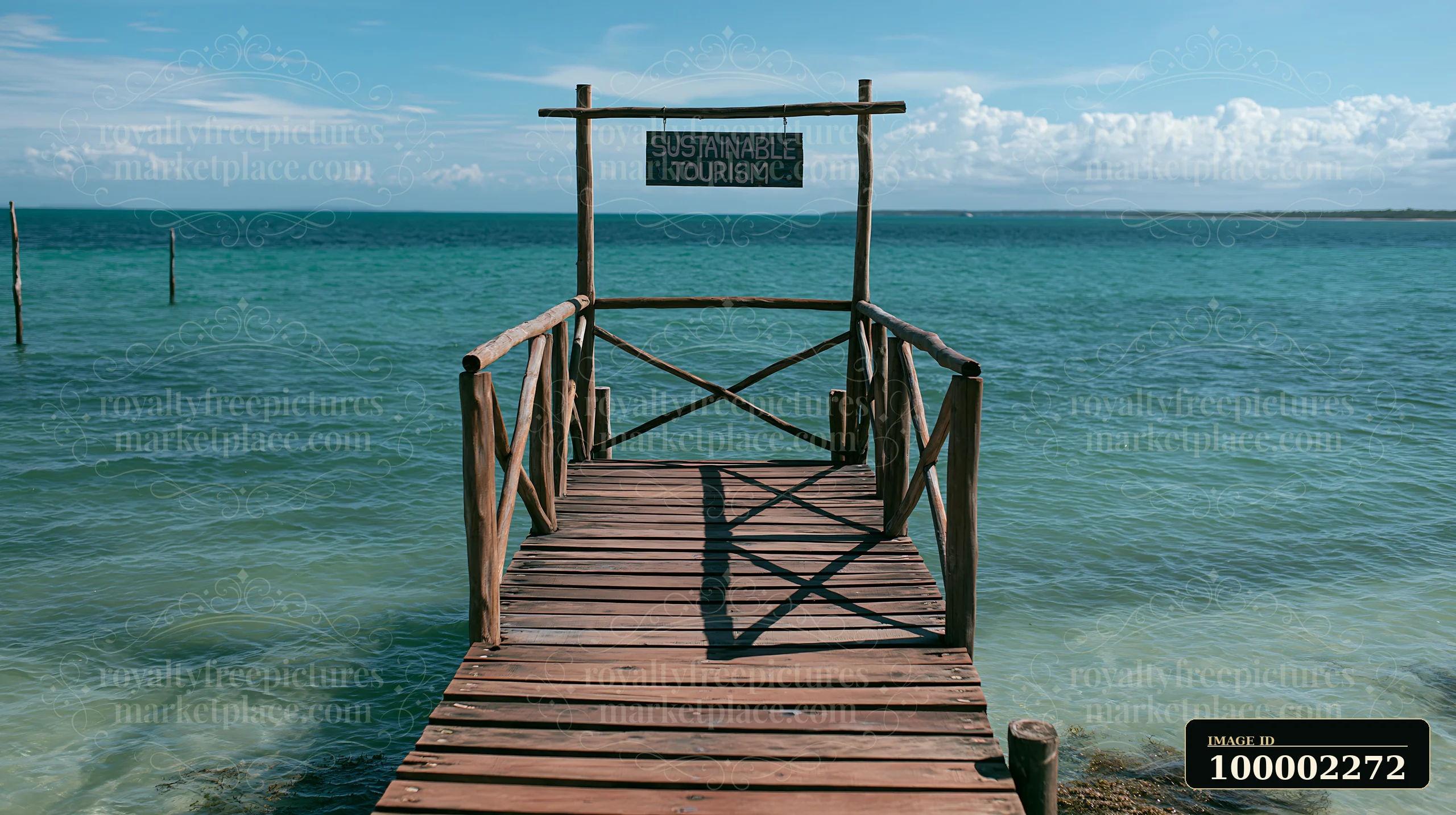 A wooden dock extends into the water with a sustainable tourism sign at the end.