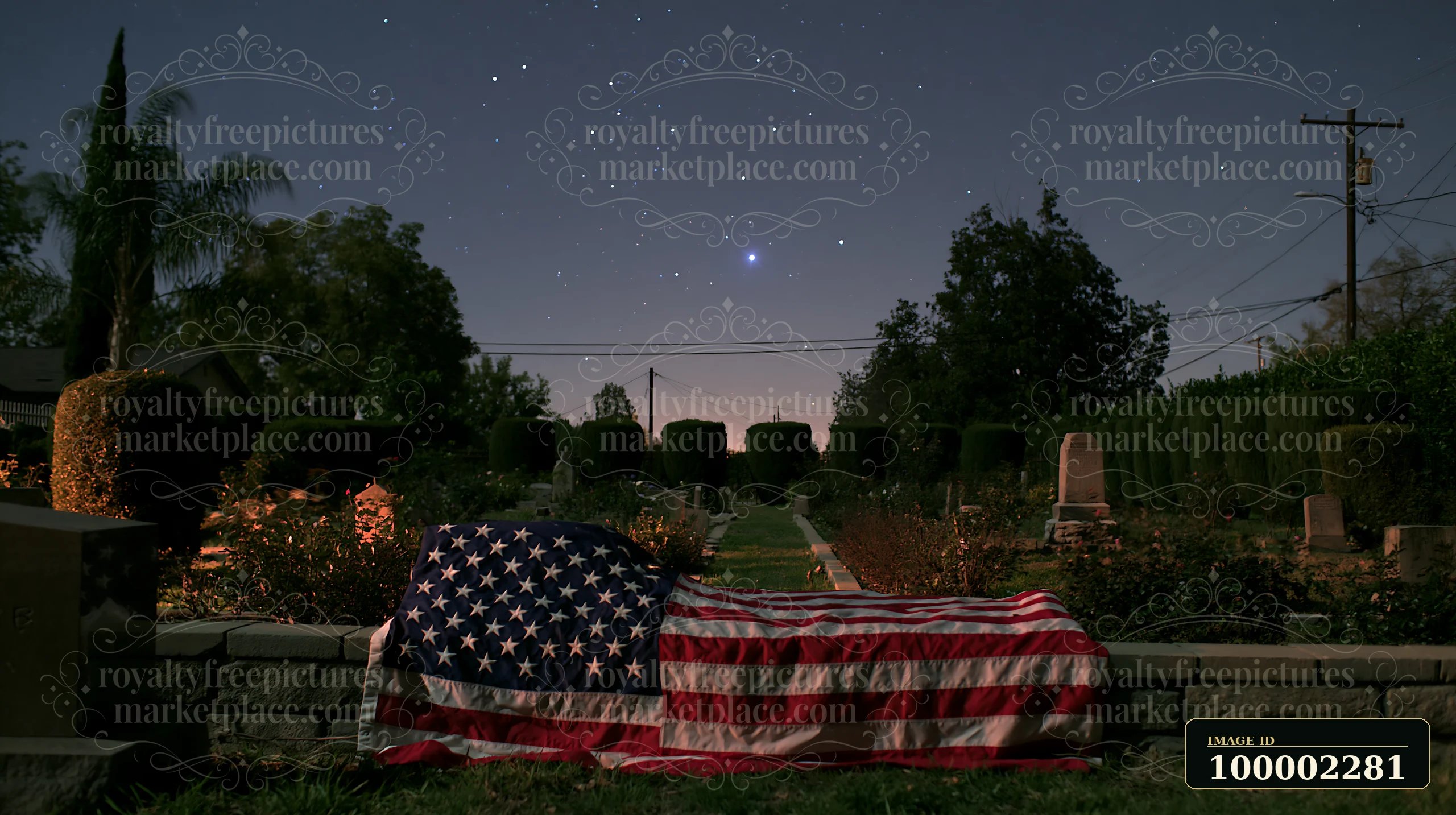 A solemn cemetery scene with American flag and stars shows a flag placed on a grave in a well-maintained cemetery.