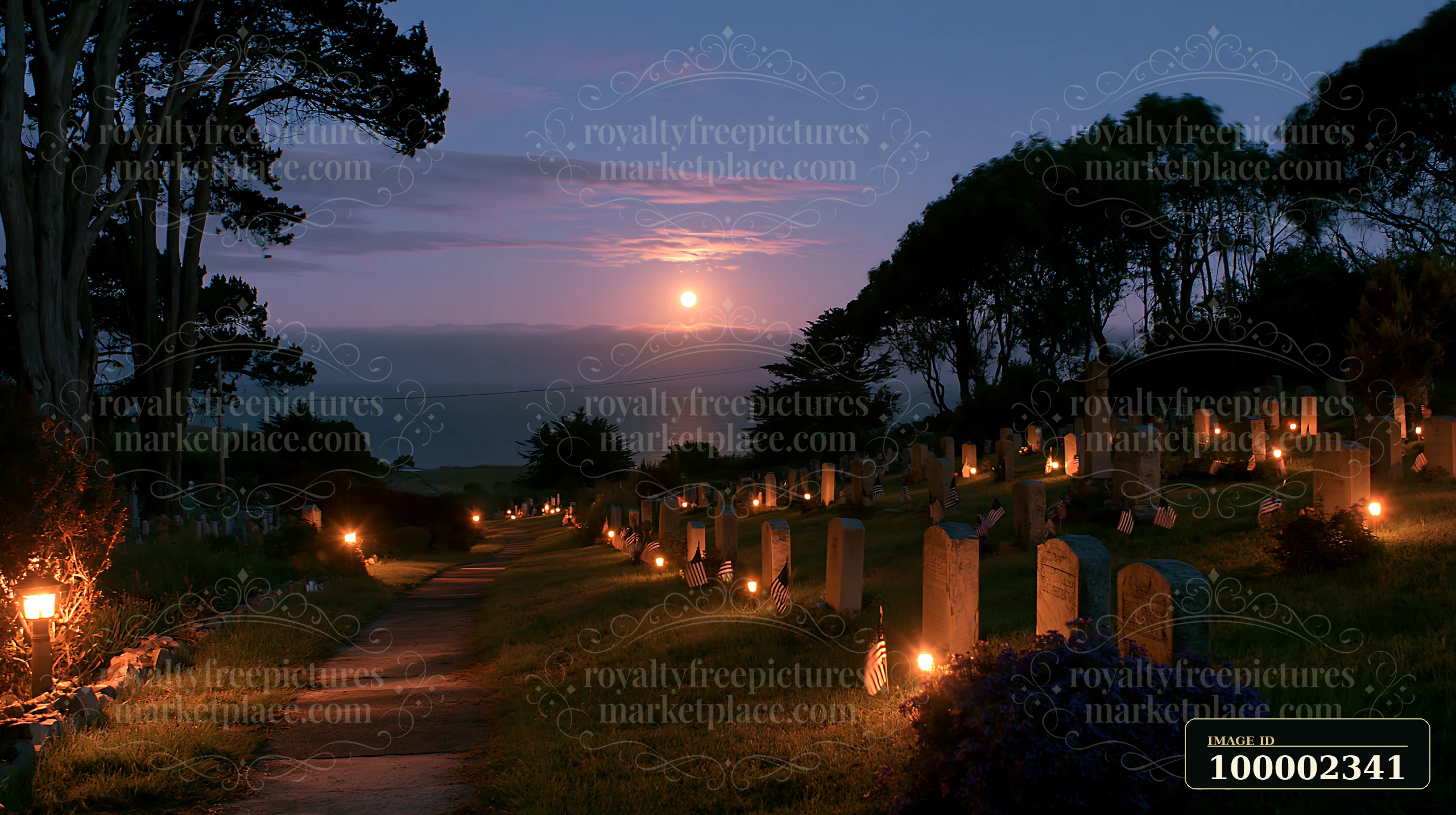Small US flags mark veteran graves at night in a cemetery, illuminated softly by lanterns.