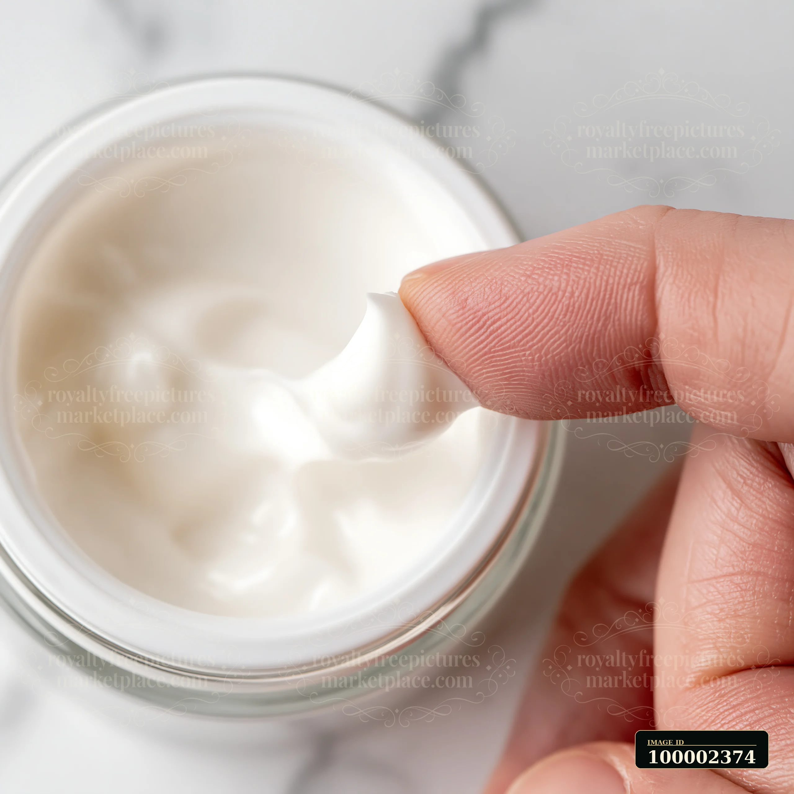 A person is shown taking a small amount of cream from a jar using a finger.