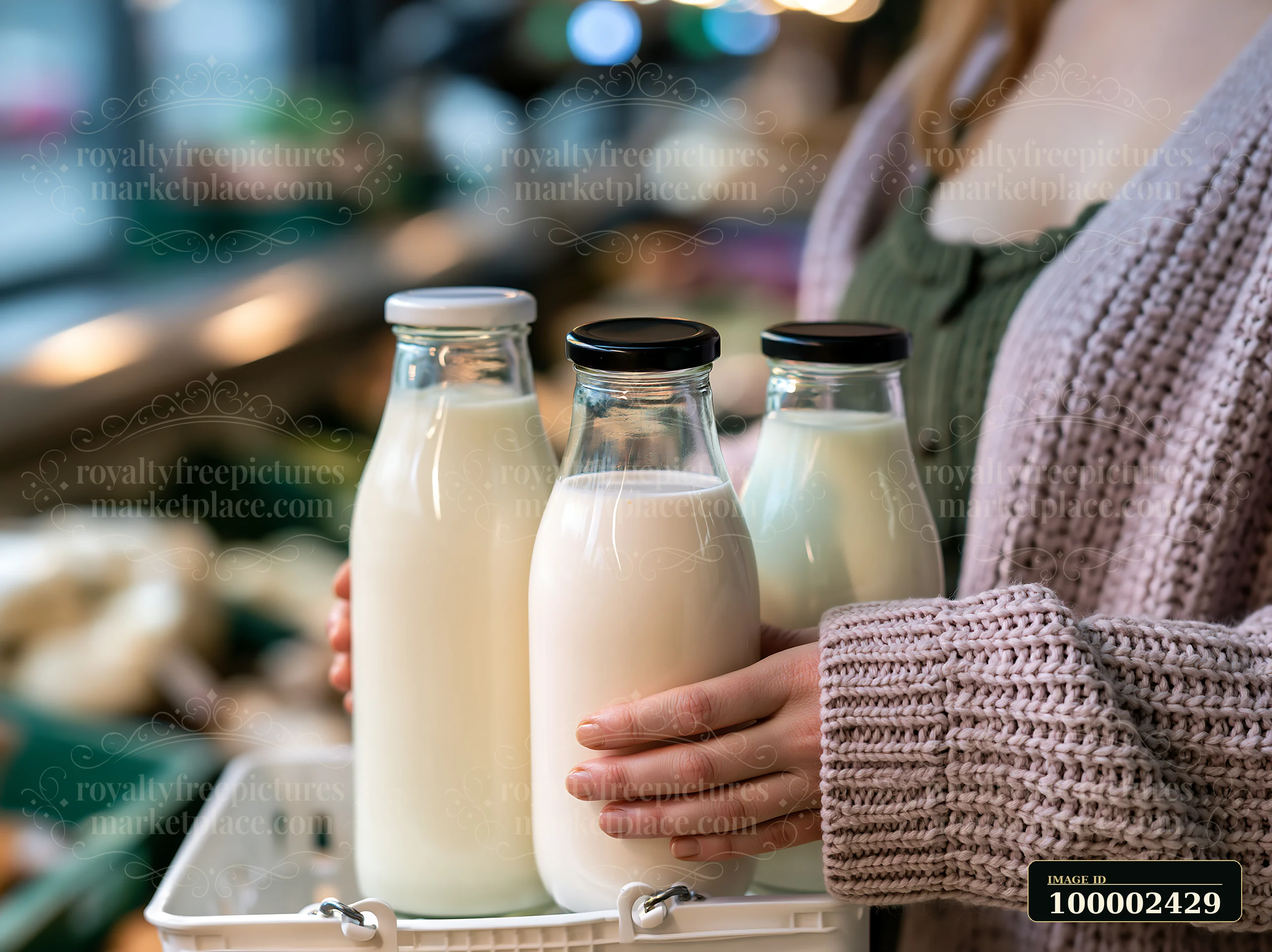 A customer at a local market compares three different bottles of milk while holding them in a basket.