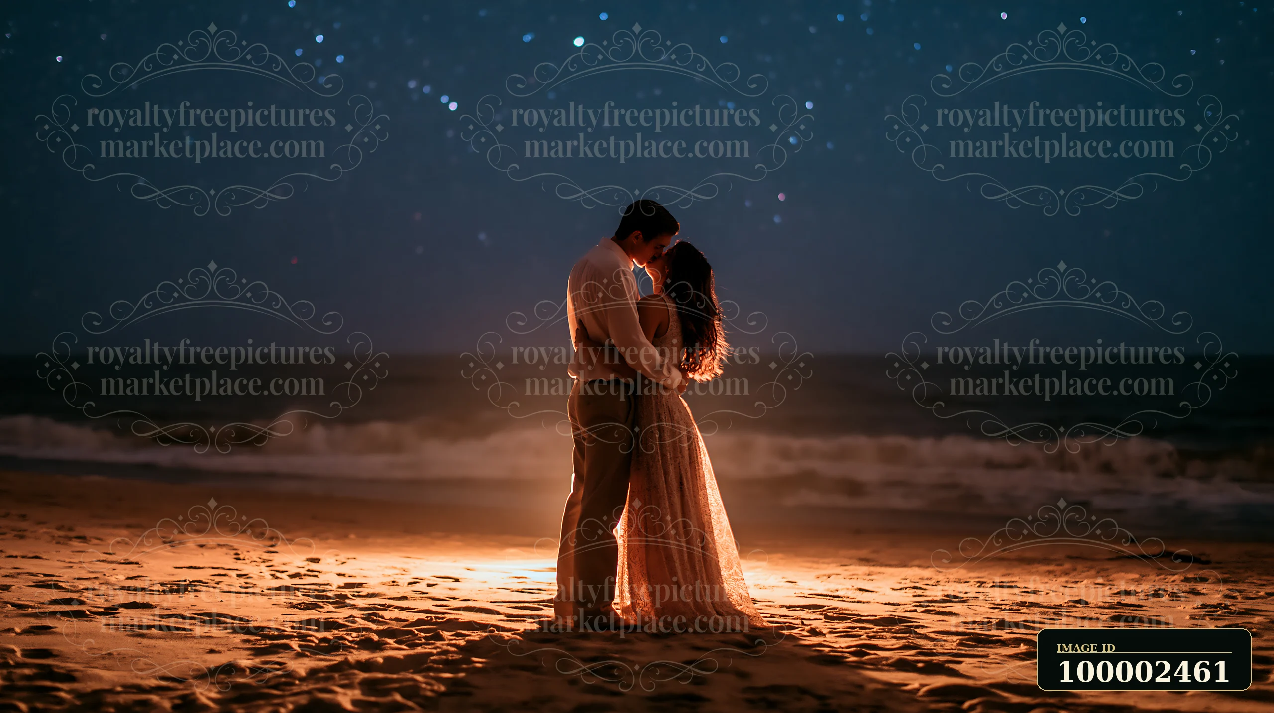 A happy couple kissing beneath stars in nature stands on the sand at night.
