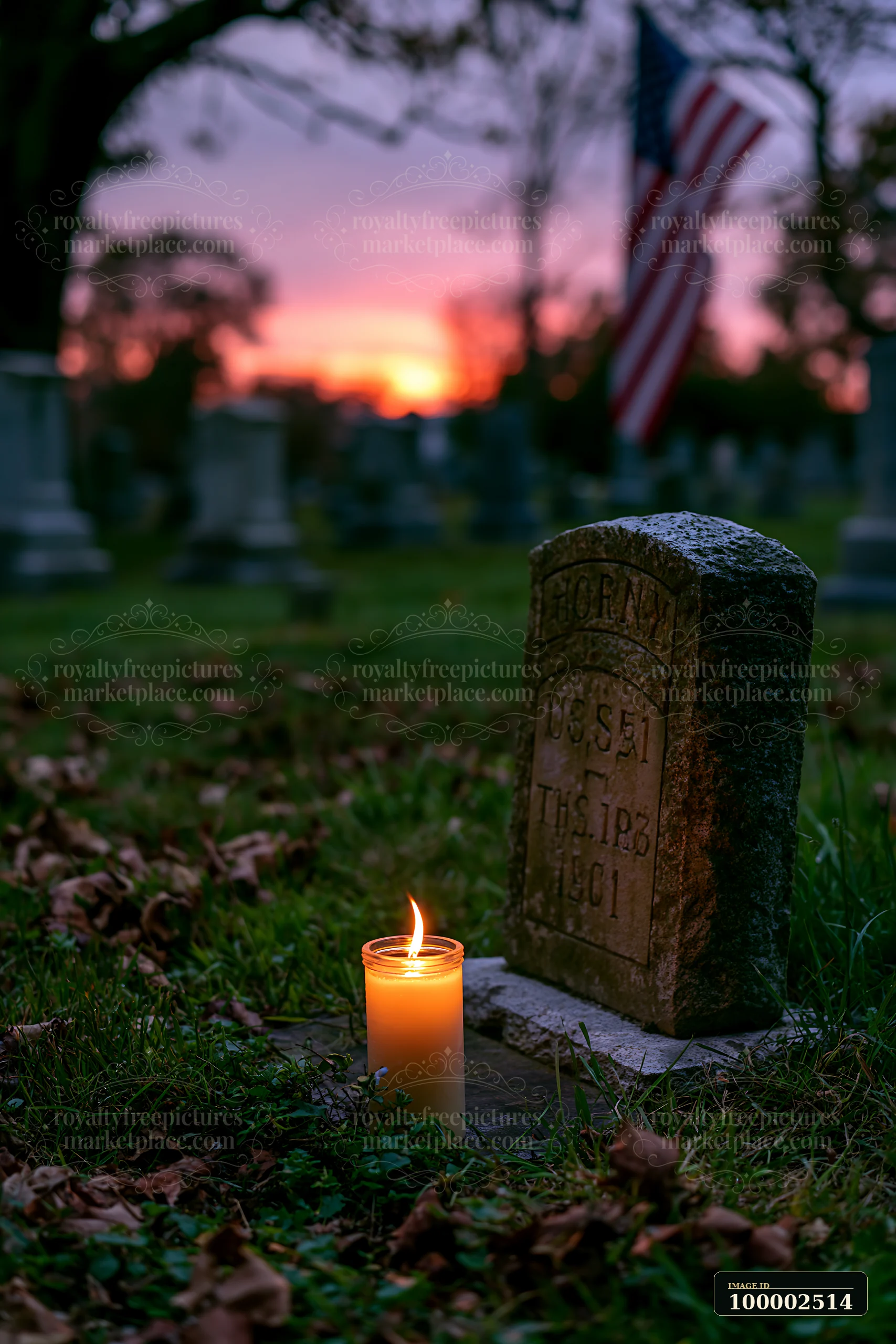 The American flag above a row of veterans graves stands tall during sunset.