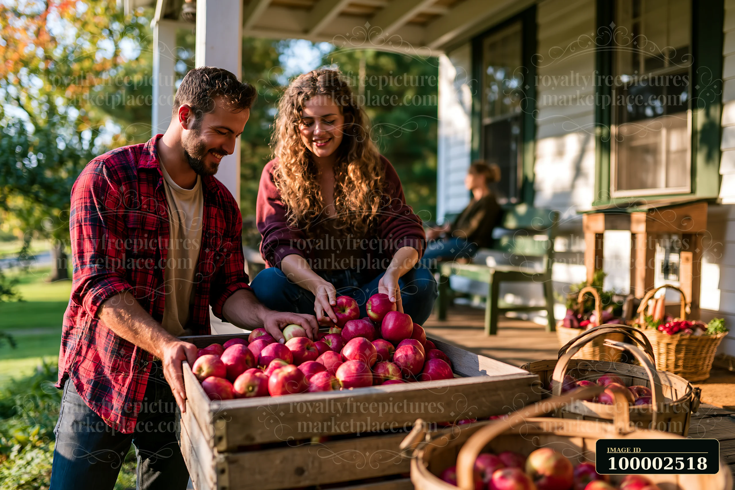 A couple on cottage porch is picking apples from a wooden crate.