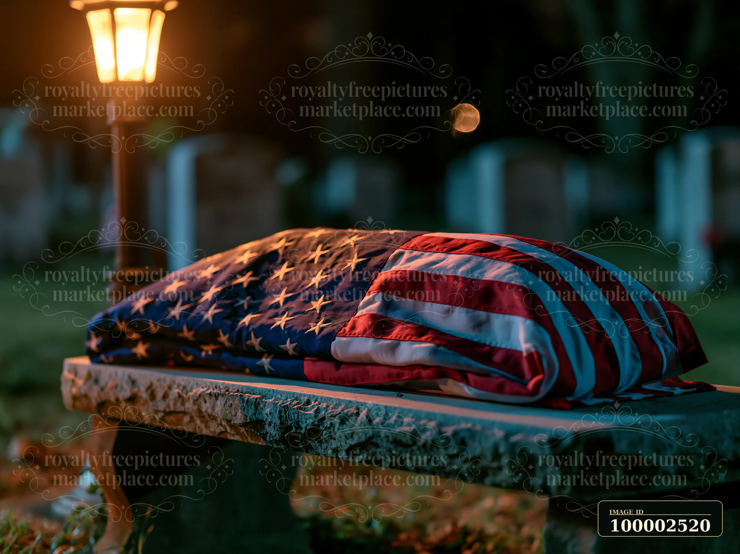 A coffin draped with an American flag rests on a stone bench in a military cemetery at night, surrounded by gravestones illuminated by a nearby lamp.