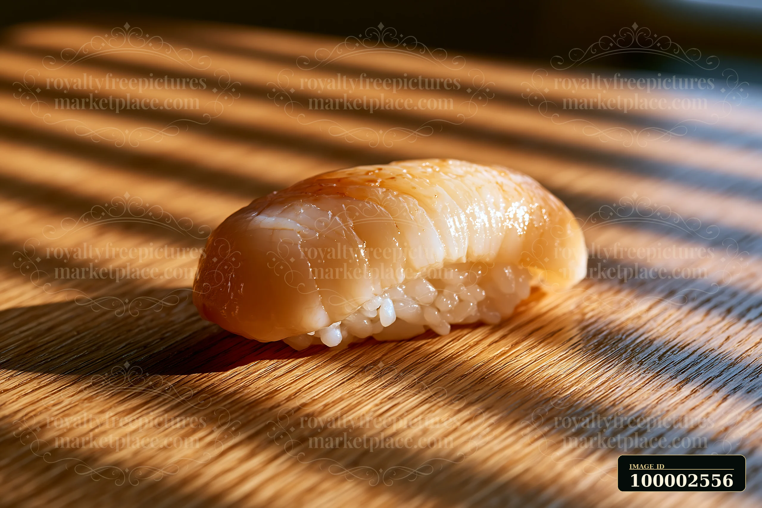 One sushi piece rests on a wooden table with natural light creating shadows.
