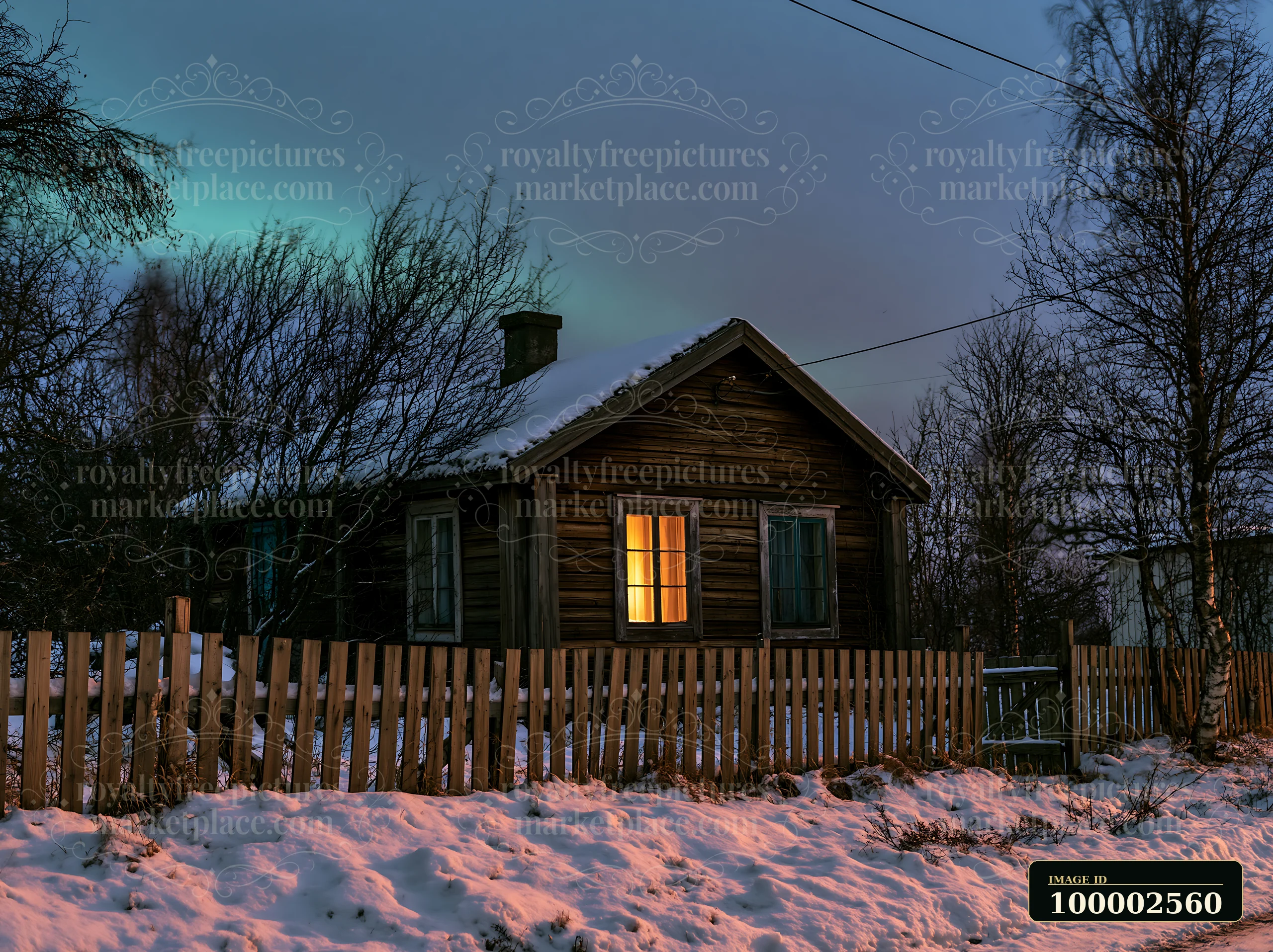 A wooden cottage sits surrounded by snow and trees under the northern lights.