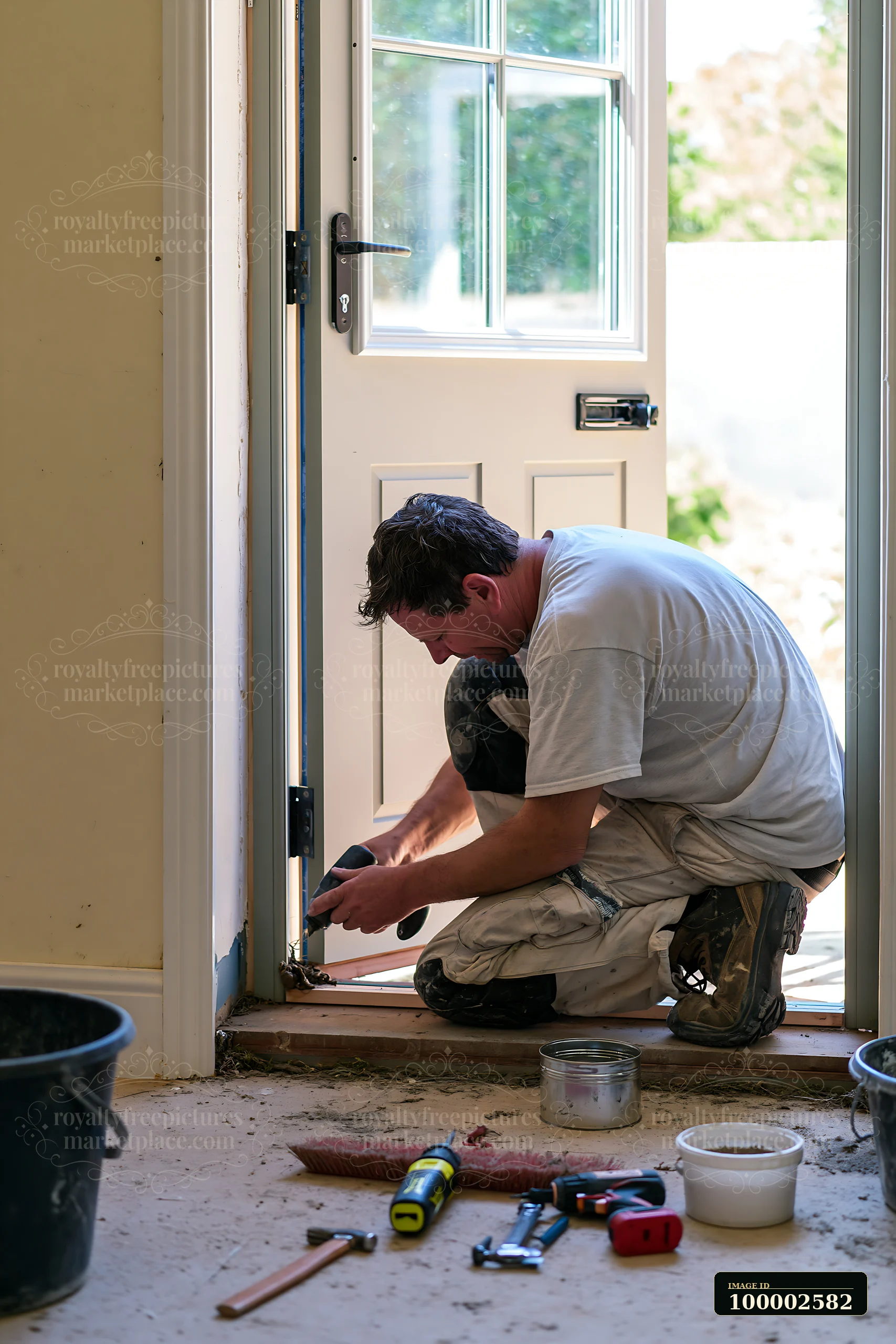 A worker focuses on installing a door in a country house.