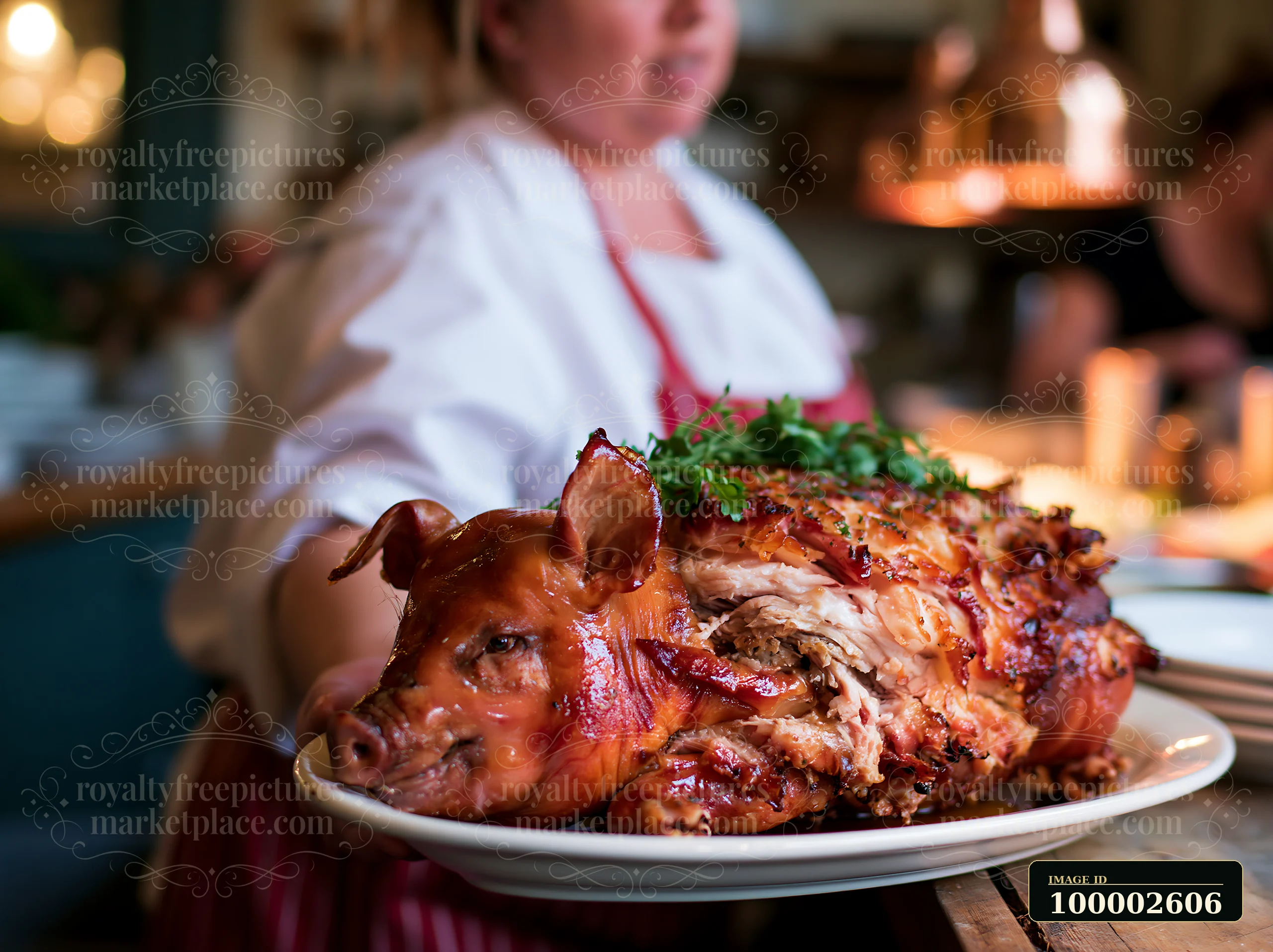 A person holds a roast pig garnished with fresh herbs in a kitchen during a festive meal preparation.