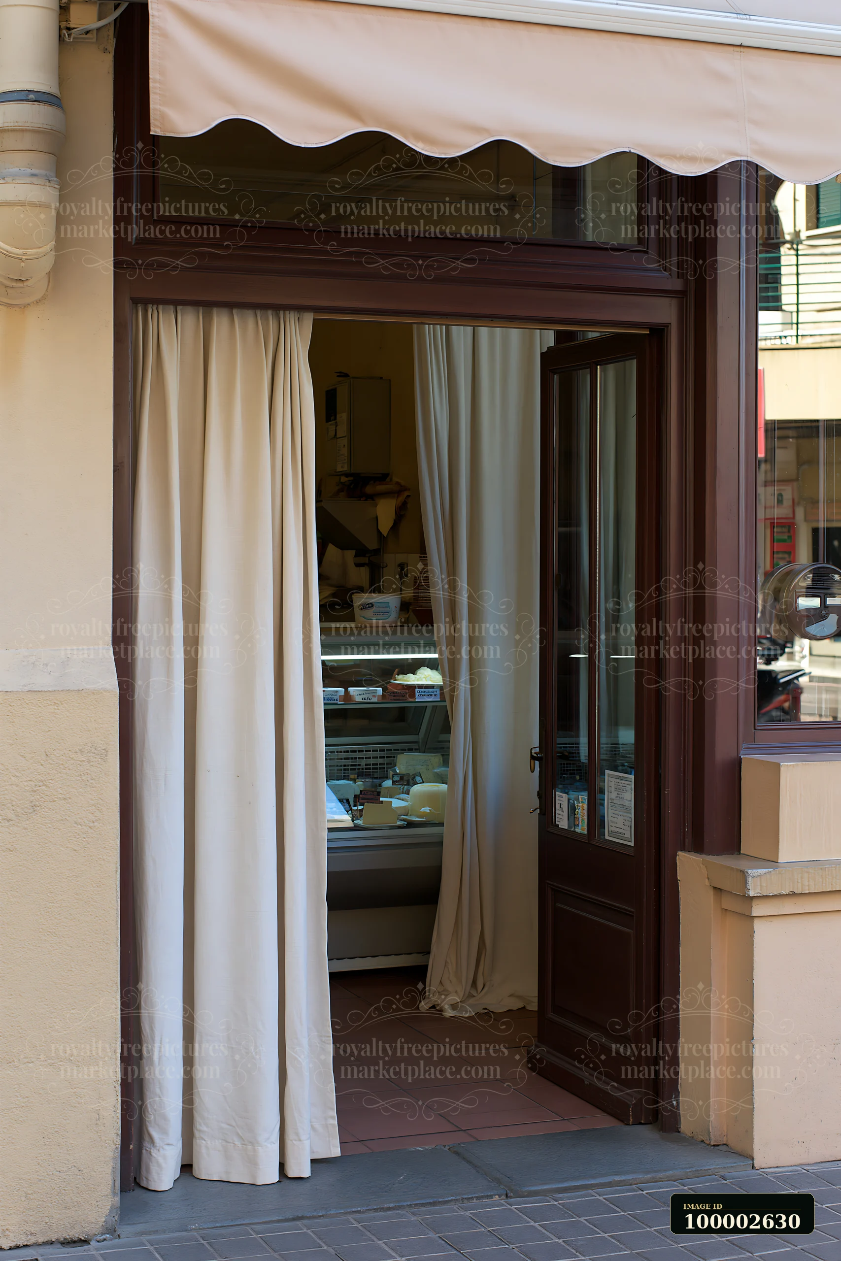 A dairy products shop on a pedestrian street has an inviting entrance with curtains.