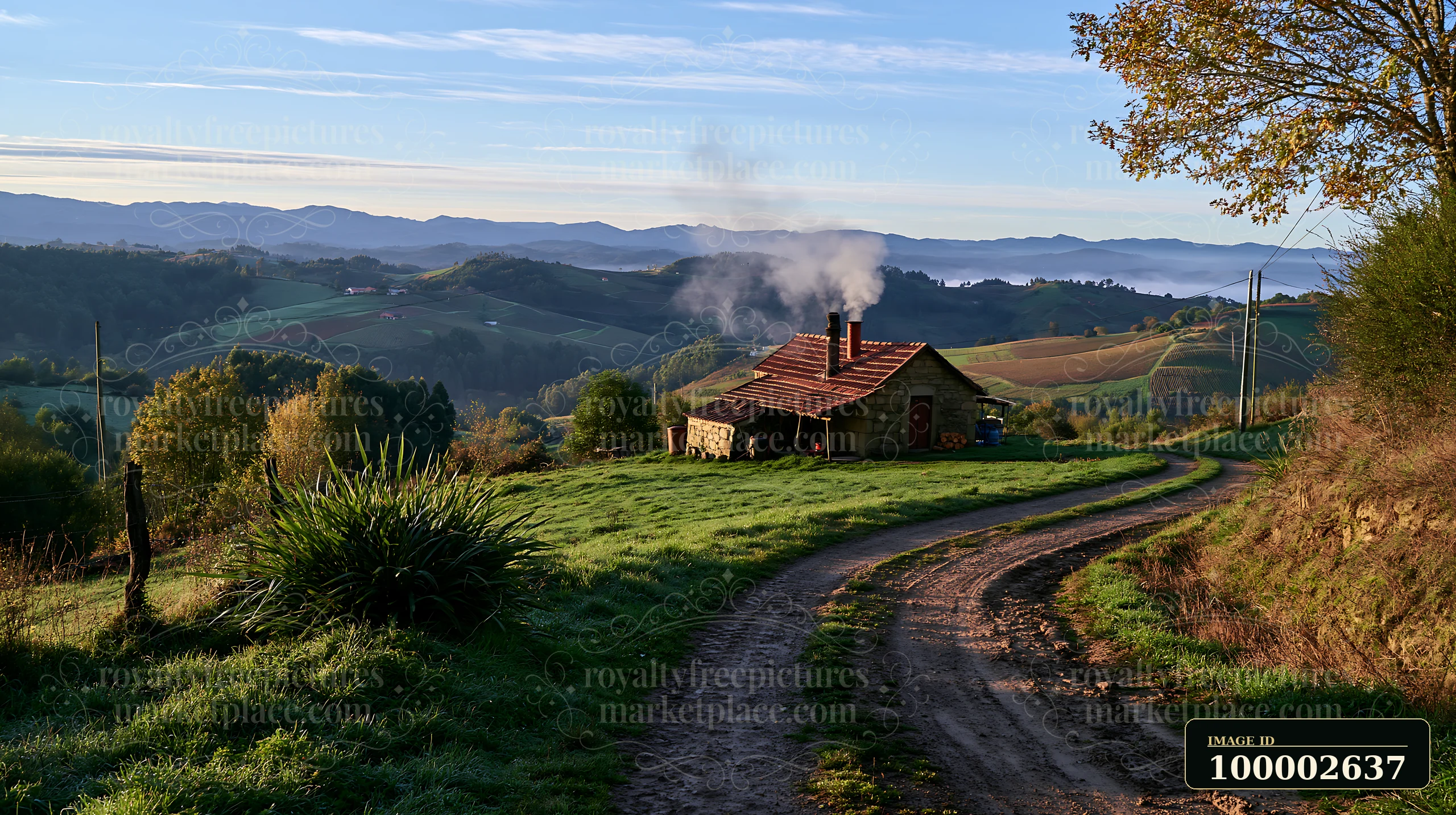 A rural cottage with chimney smoke sits beside a winding dirt road surrounded by green hills and trees.