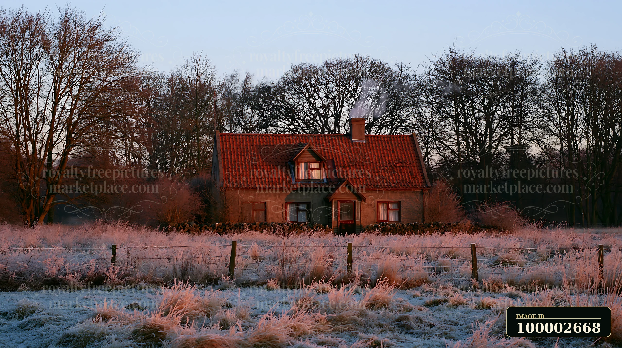 A rural cottage with chimney smoke sits in a field surrounded by frost-covered grass and trees at dawn.