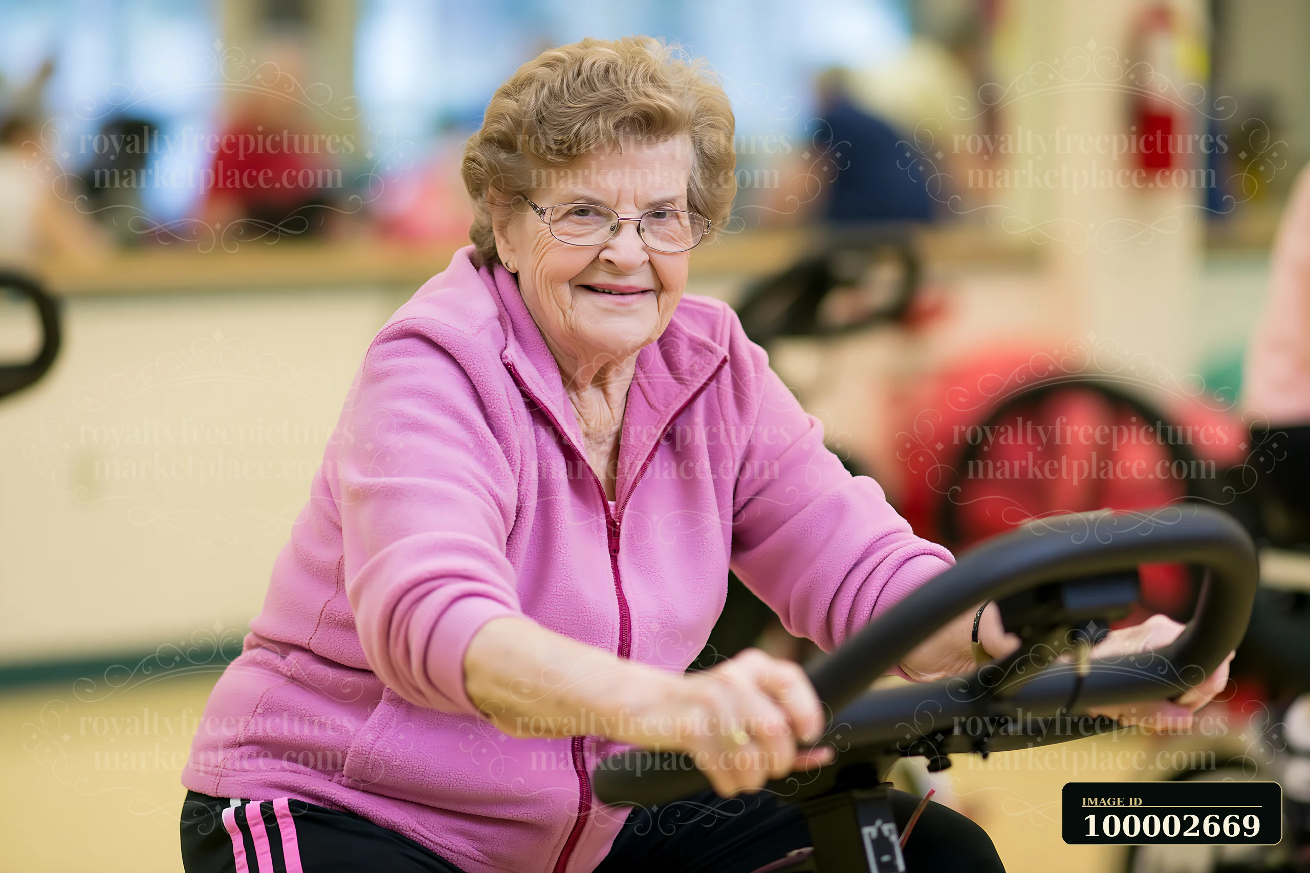 A senior with Parkinson's using a stationary bicycle smiles while participating in a group fitness program at a community center.