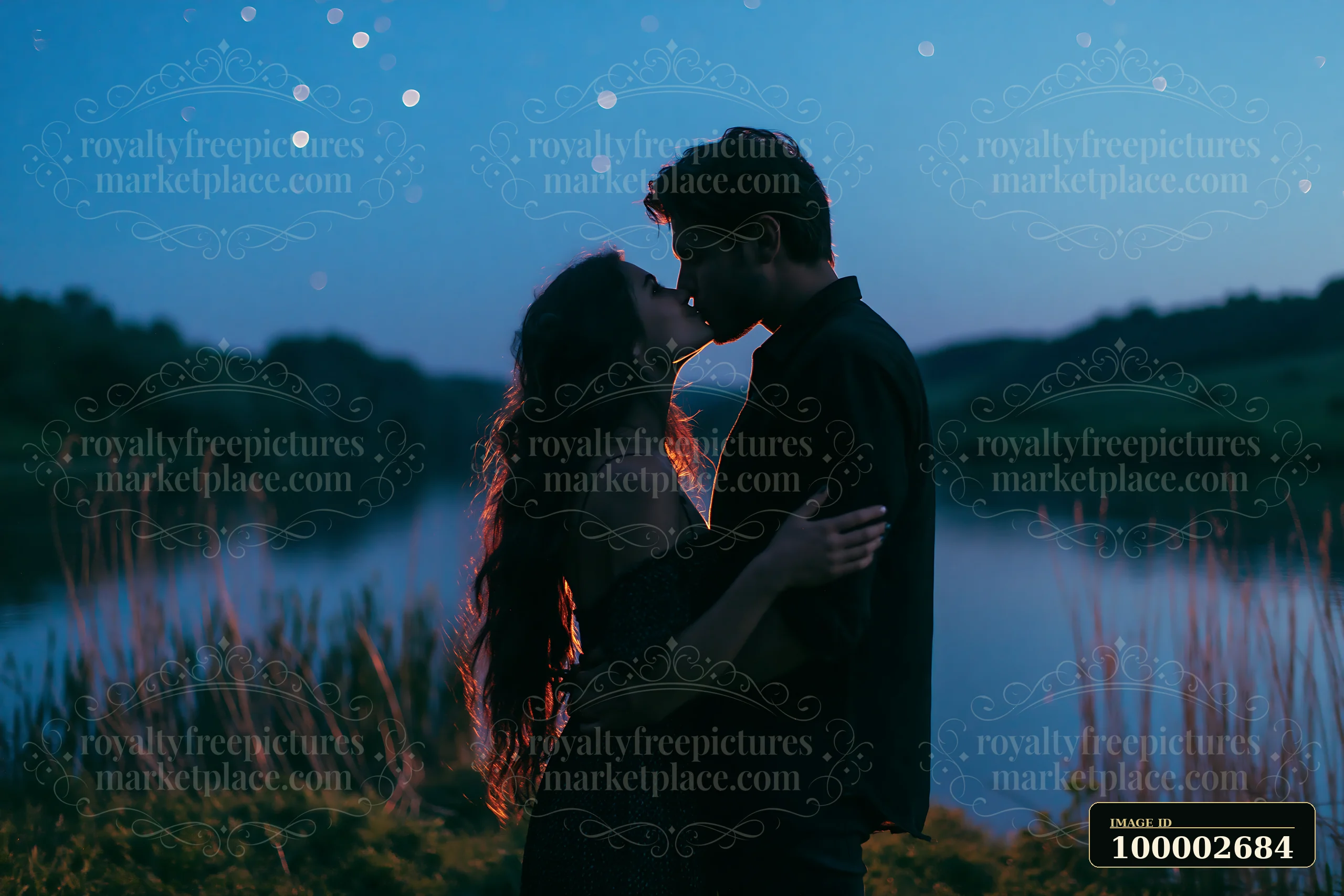 A happy couple kissing beneath stars in nature at lakeside during twilight.