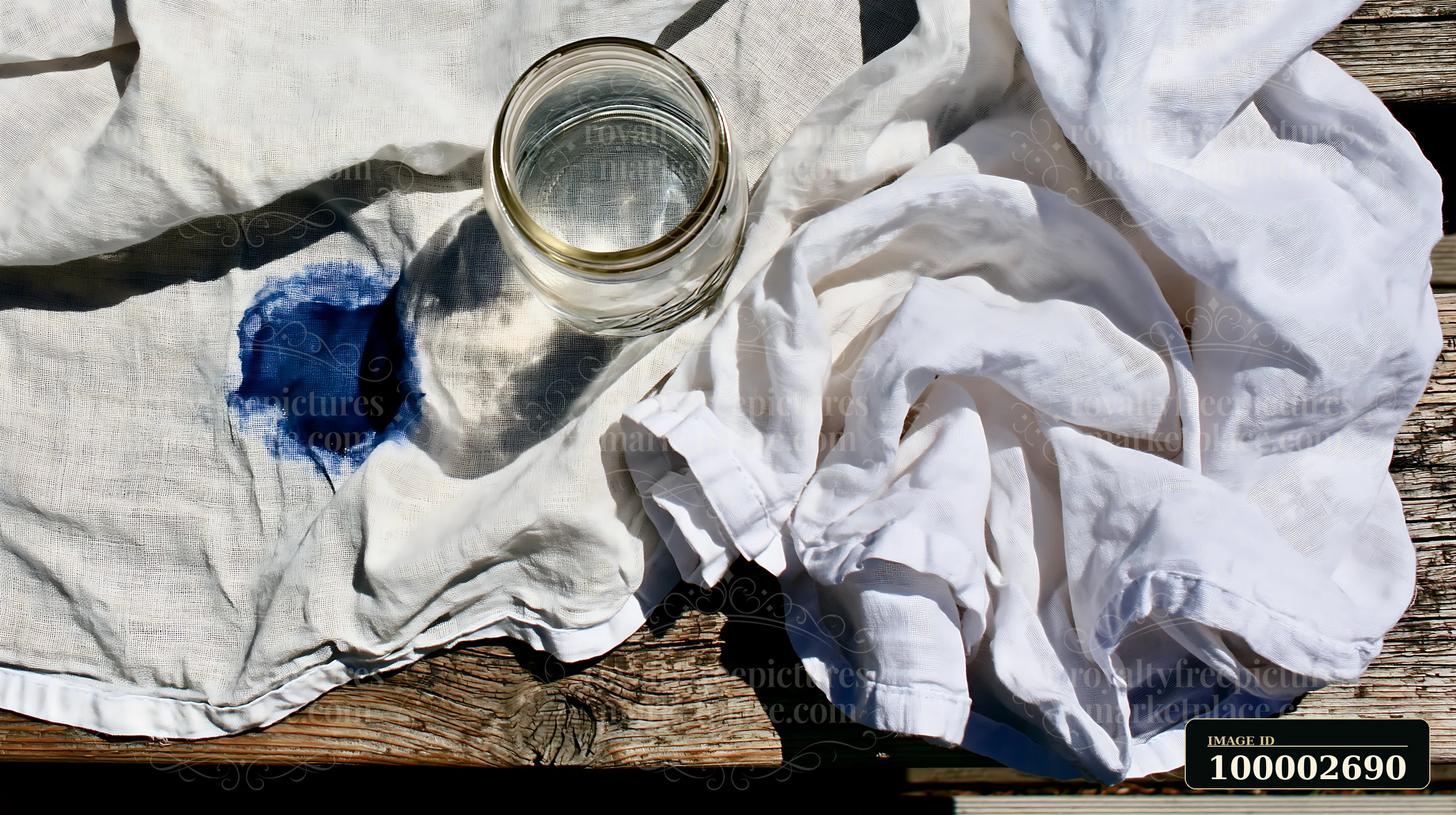 A blue watercolor stain on muslin fabric is shown next to a clear glass filled with water.