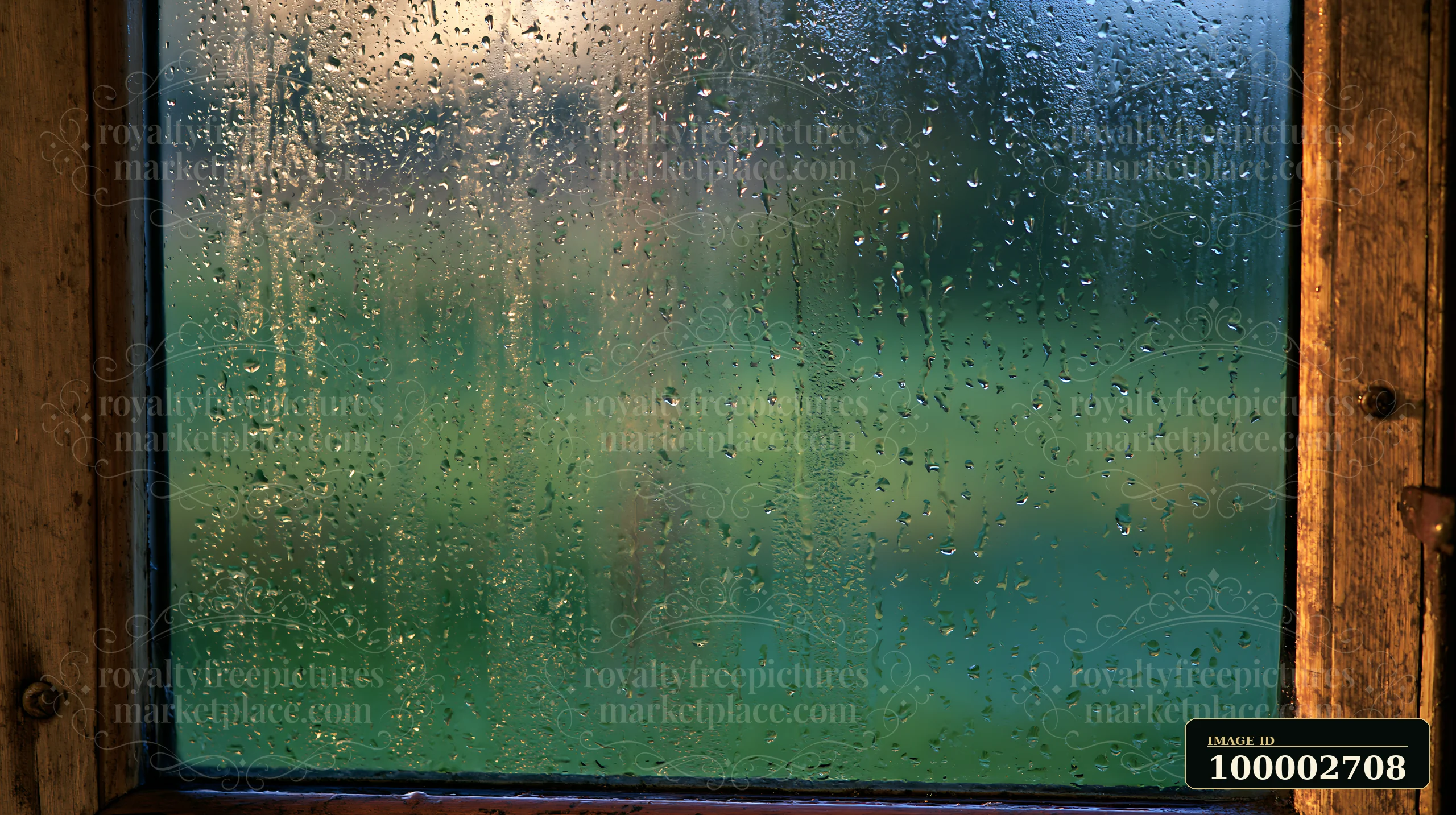 Water droplets cling to a rustic glass pane, showcasing a blurred green landscape outside as light filters in, creating a cozy atmosphere.