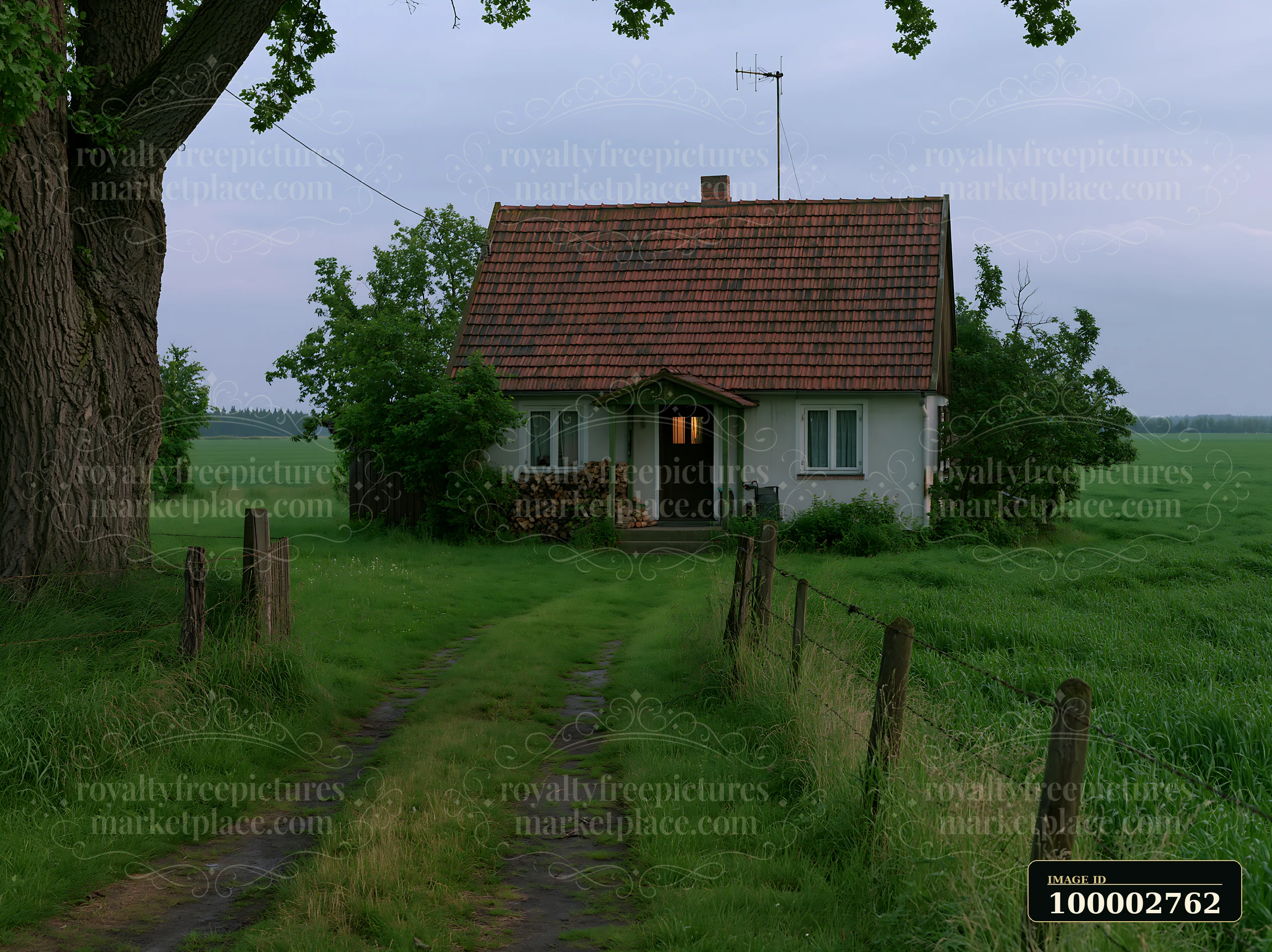 A farmhouse is located amidst green fields with a dirt path leading to it.