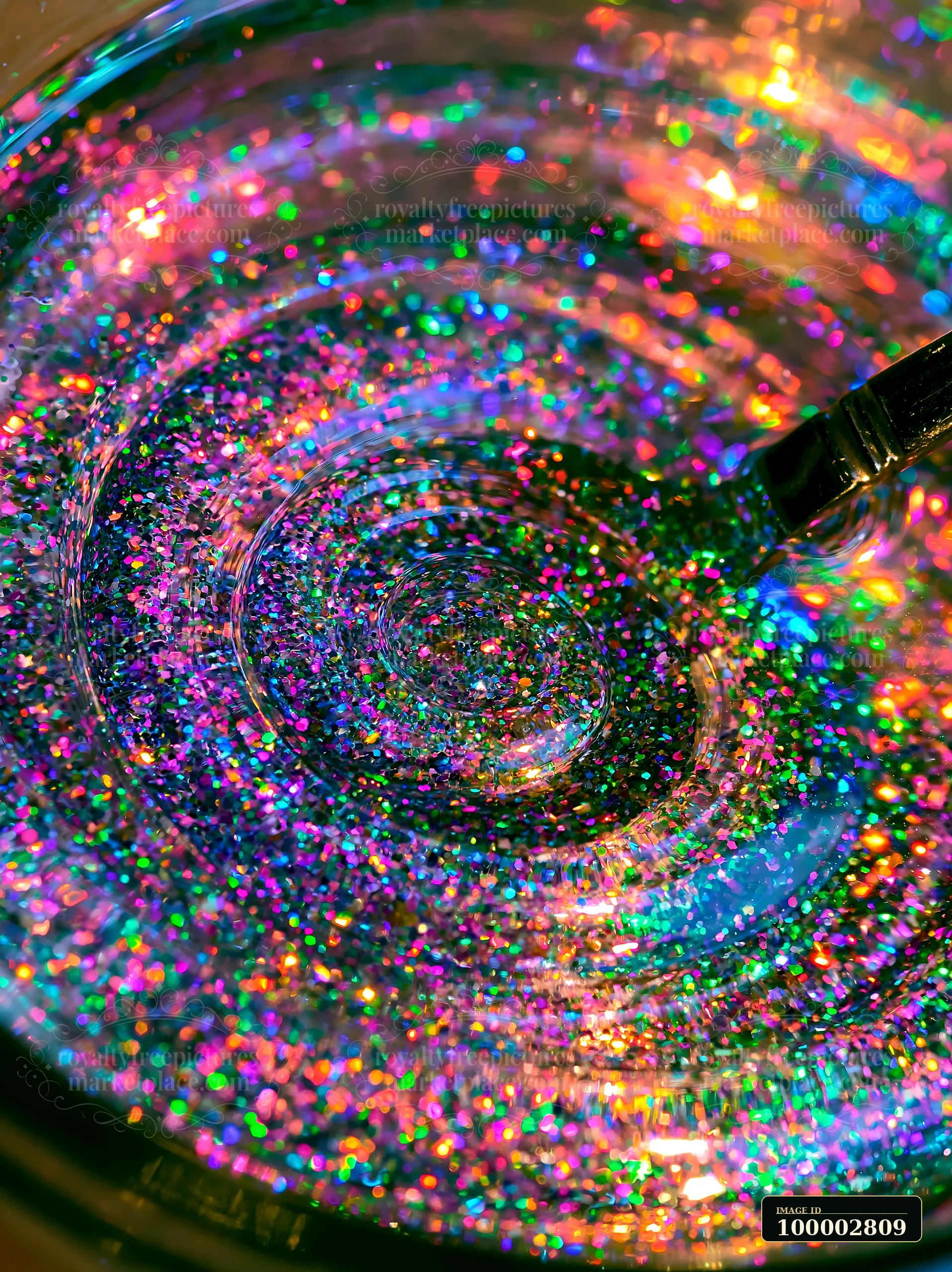 A swirl of multicolor glitter moves within a clear liquid, creating a mesmerizing pattern.