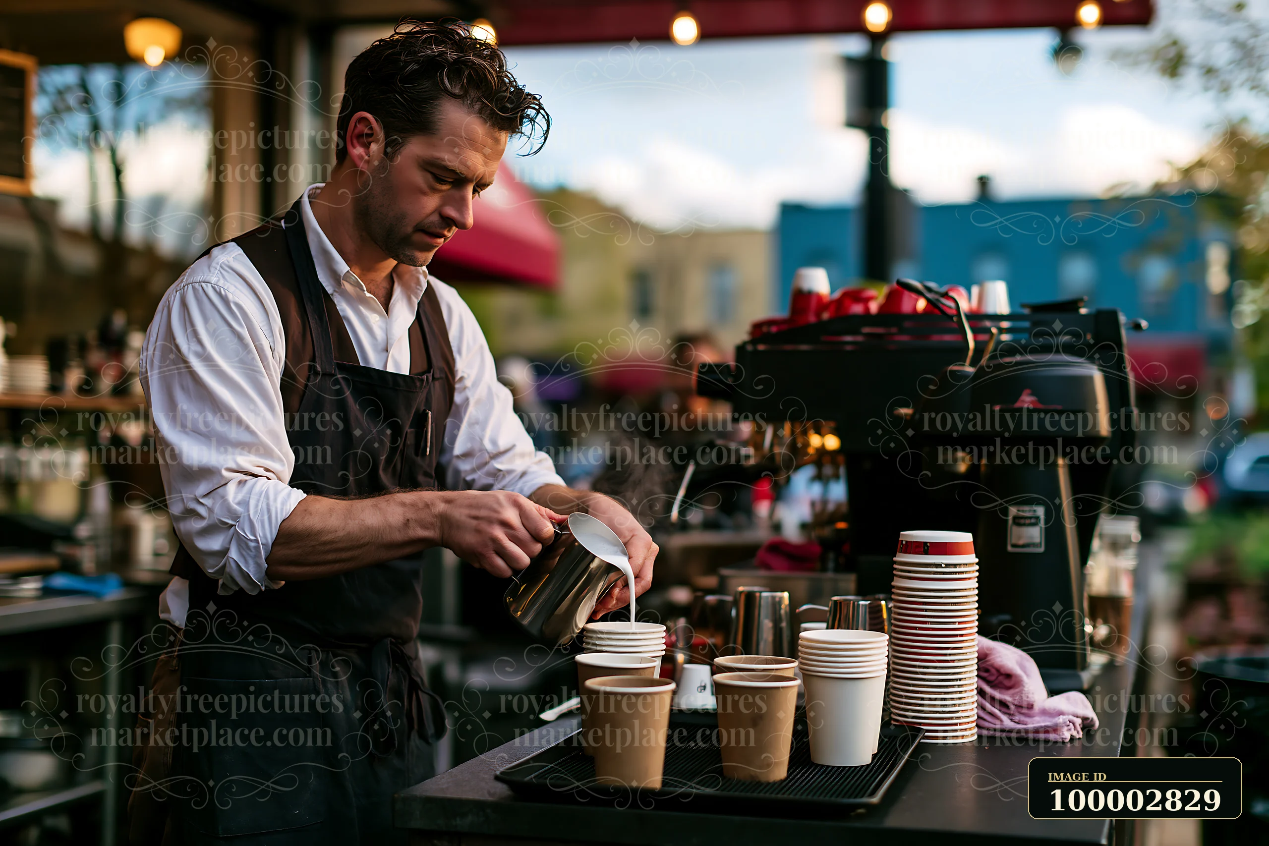 A barista steaming milk at a street cafe prepares coffee drinks for customers.