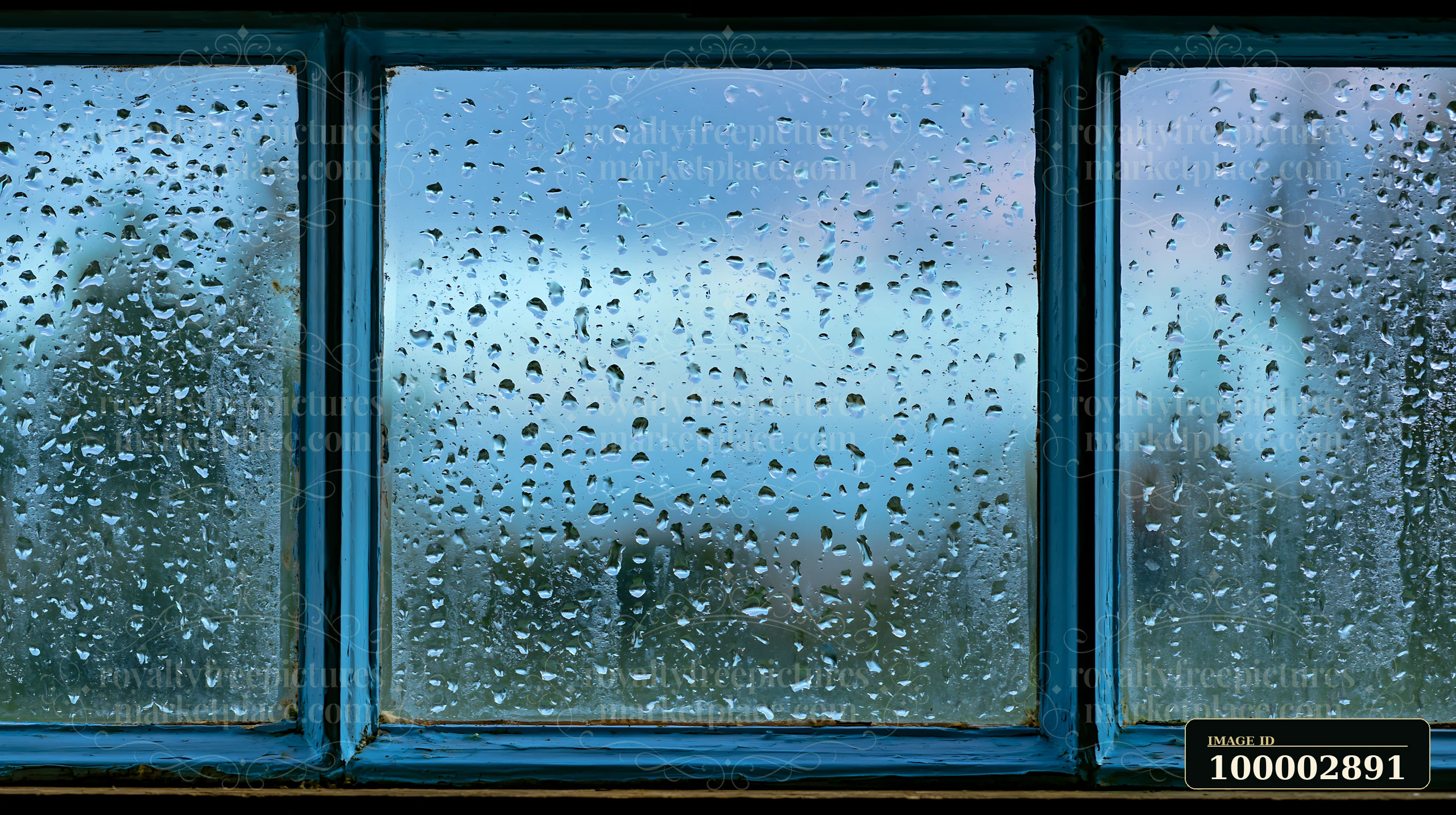 Close-up droplets on rustic glass pane show raindrops collecting on the window.