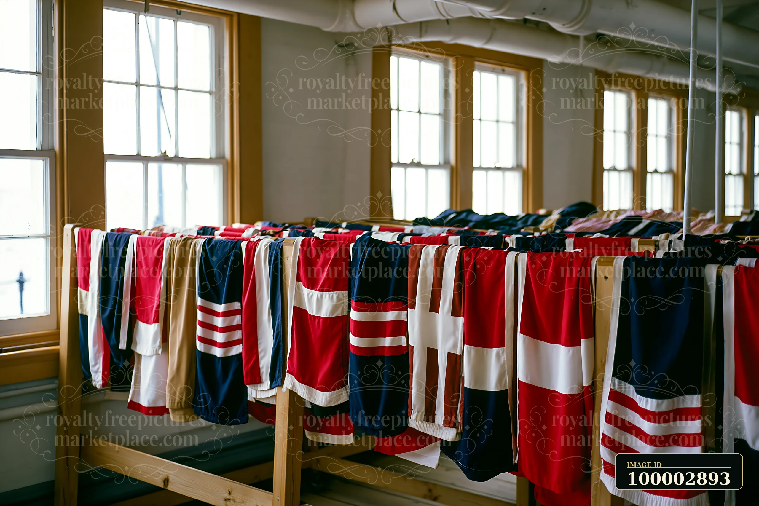 The lighthouse museum interior features rows of colorful flags hanging on wooden racks, with sunlight streaming through large windows creating a bright space.