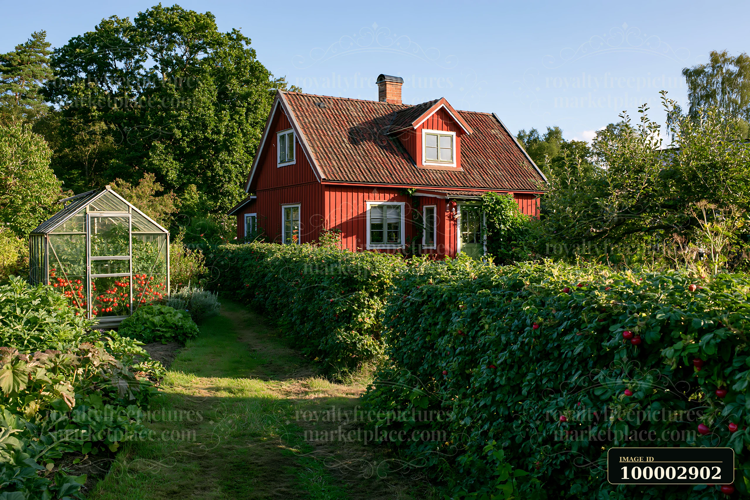 A red country house surrounded by hedges stands in a garden during the day.