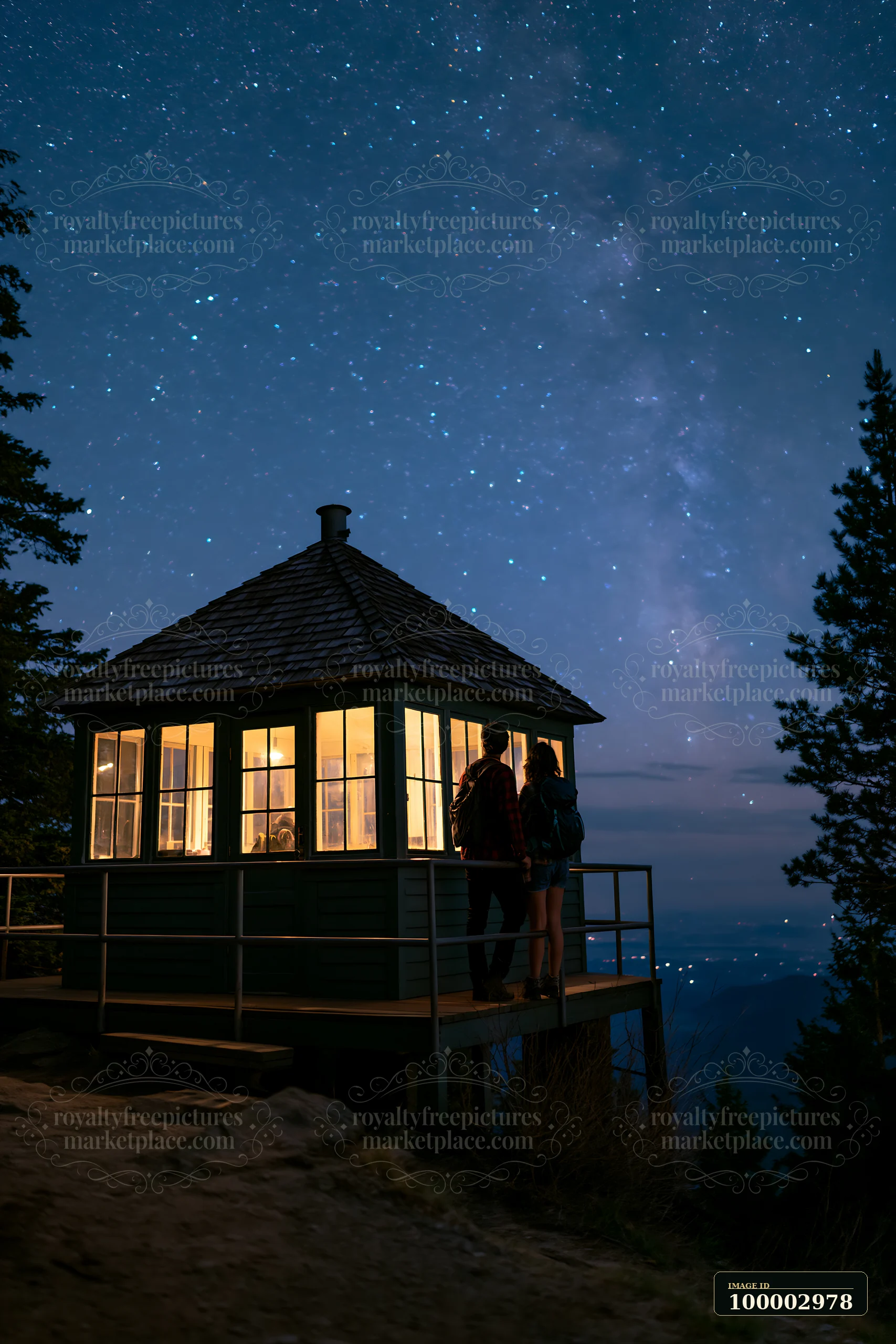 A couple watches stars from a mountain lookout cabin.