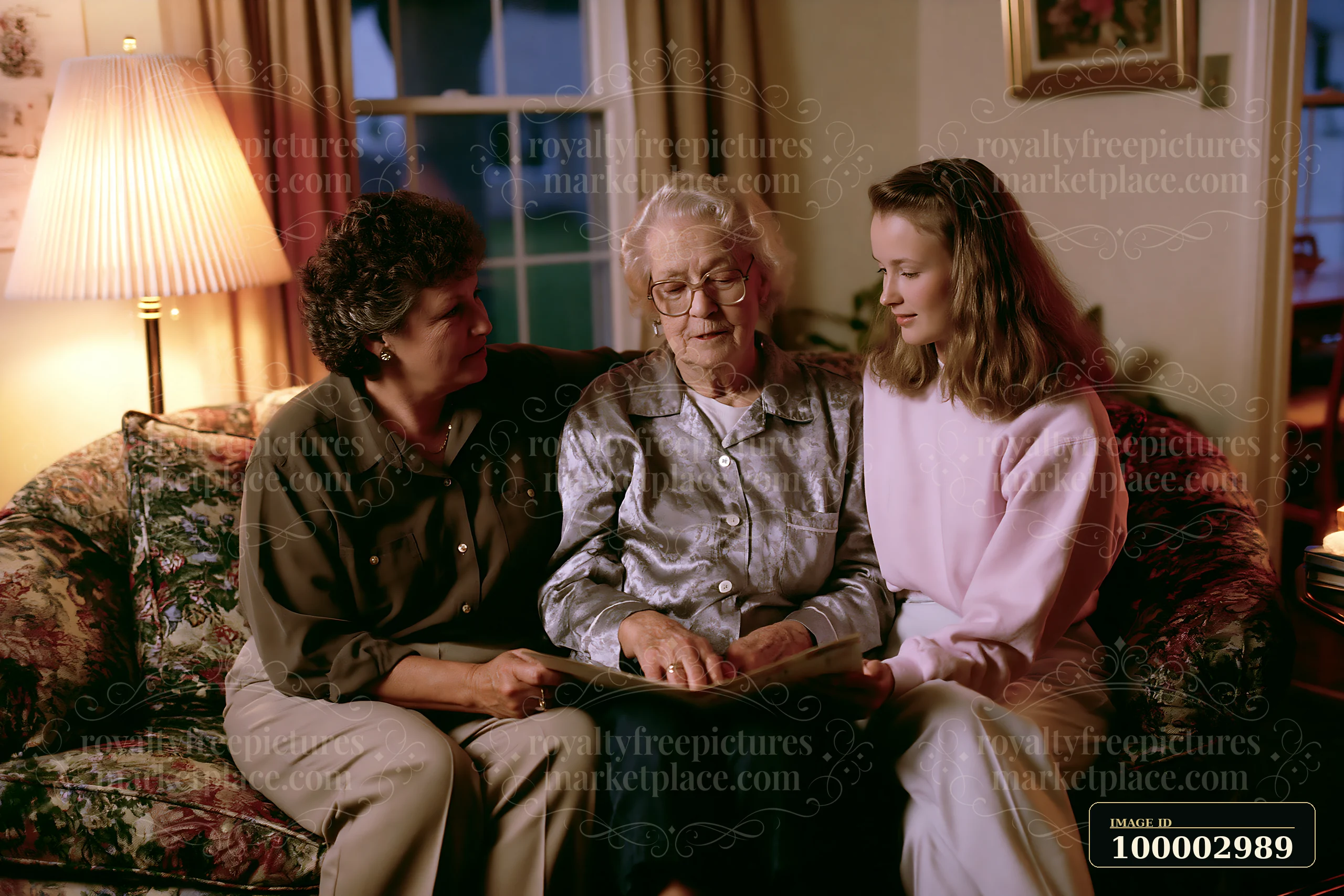 Family visiting a Parkinson's patient at home, where two women are seated beside an elderly woman, engaging in conversation and sharing a book on a cozy couch i
