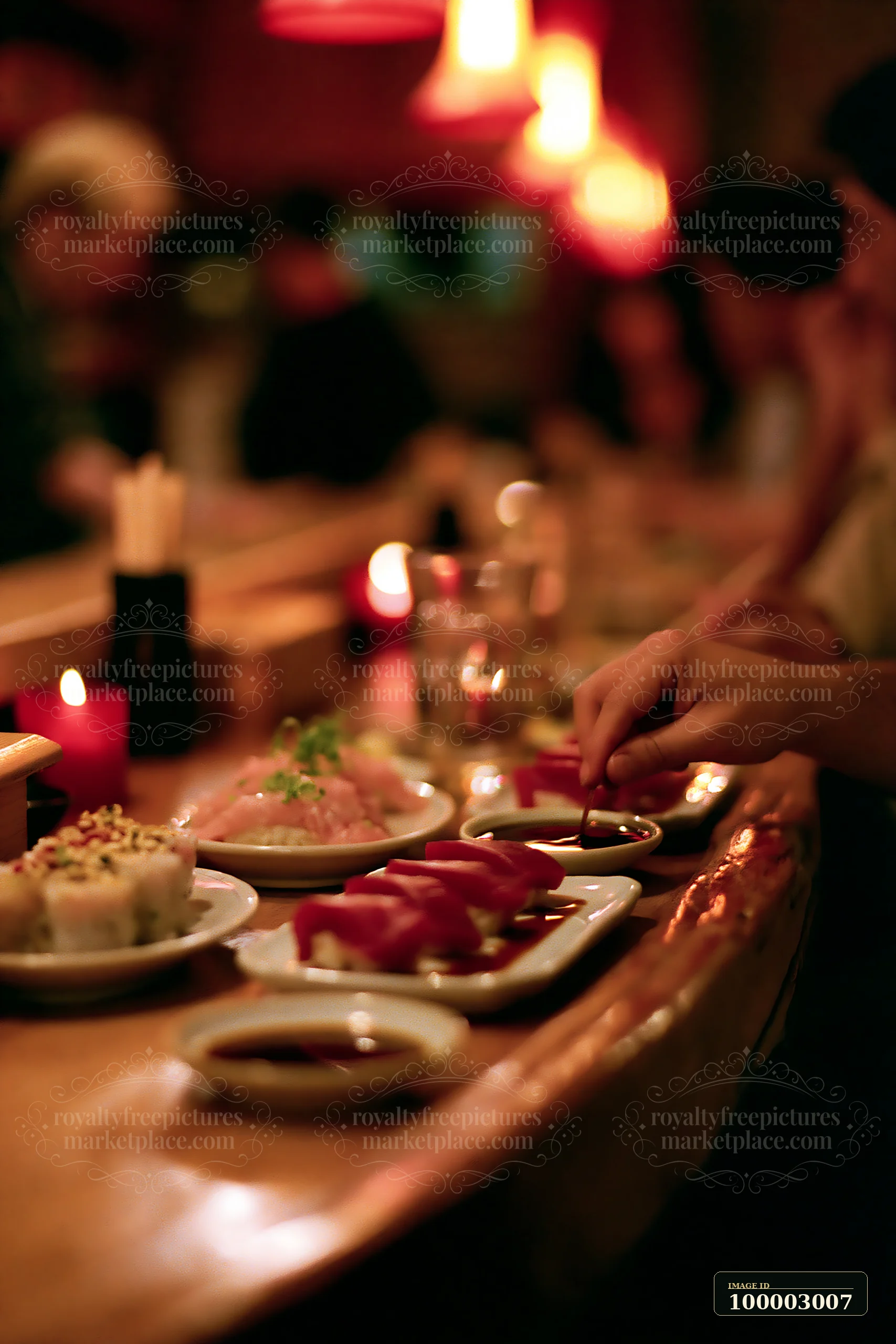 Diners enjoy sushi dinner under warm lighting at a bar counter with various rolls and plates arranged.