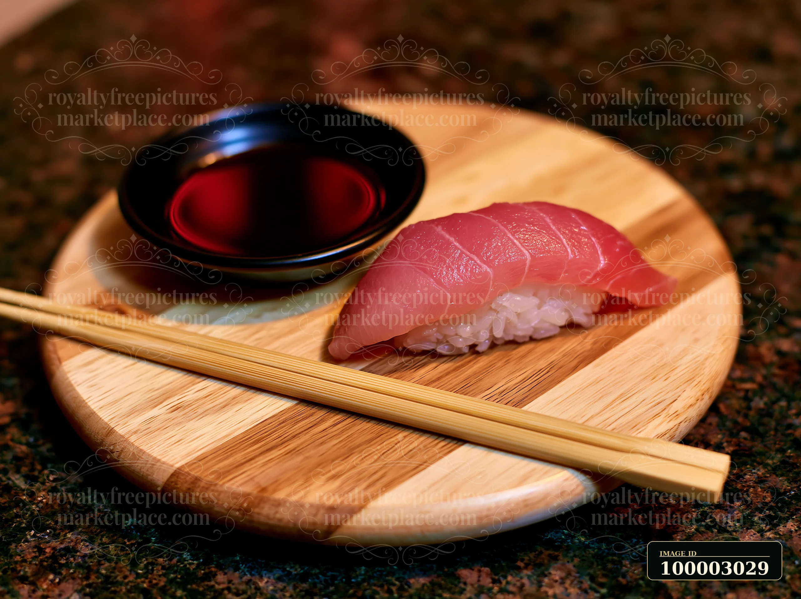 One nigiri beside soy sauce dish is served on a round wooden plate with chopsticks.