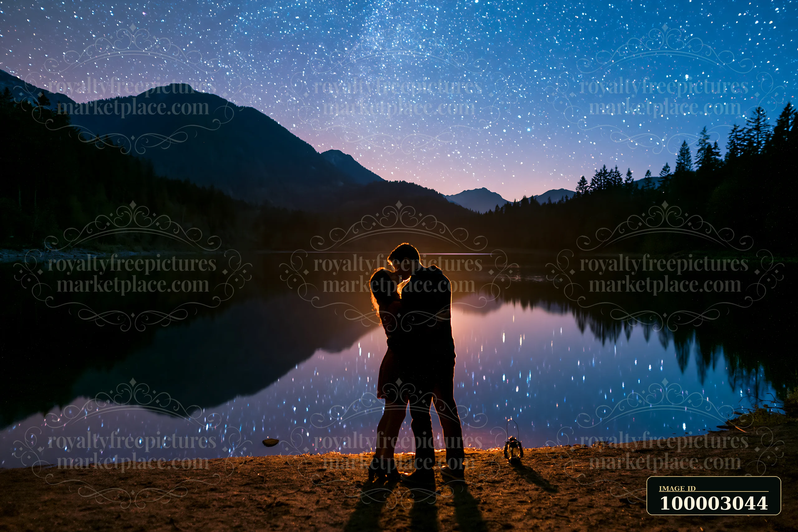 A couple is kissing under stars beside a lake at night, surrounded by mountains and trees.