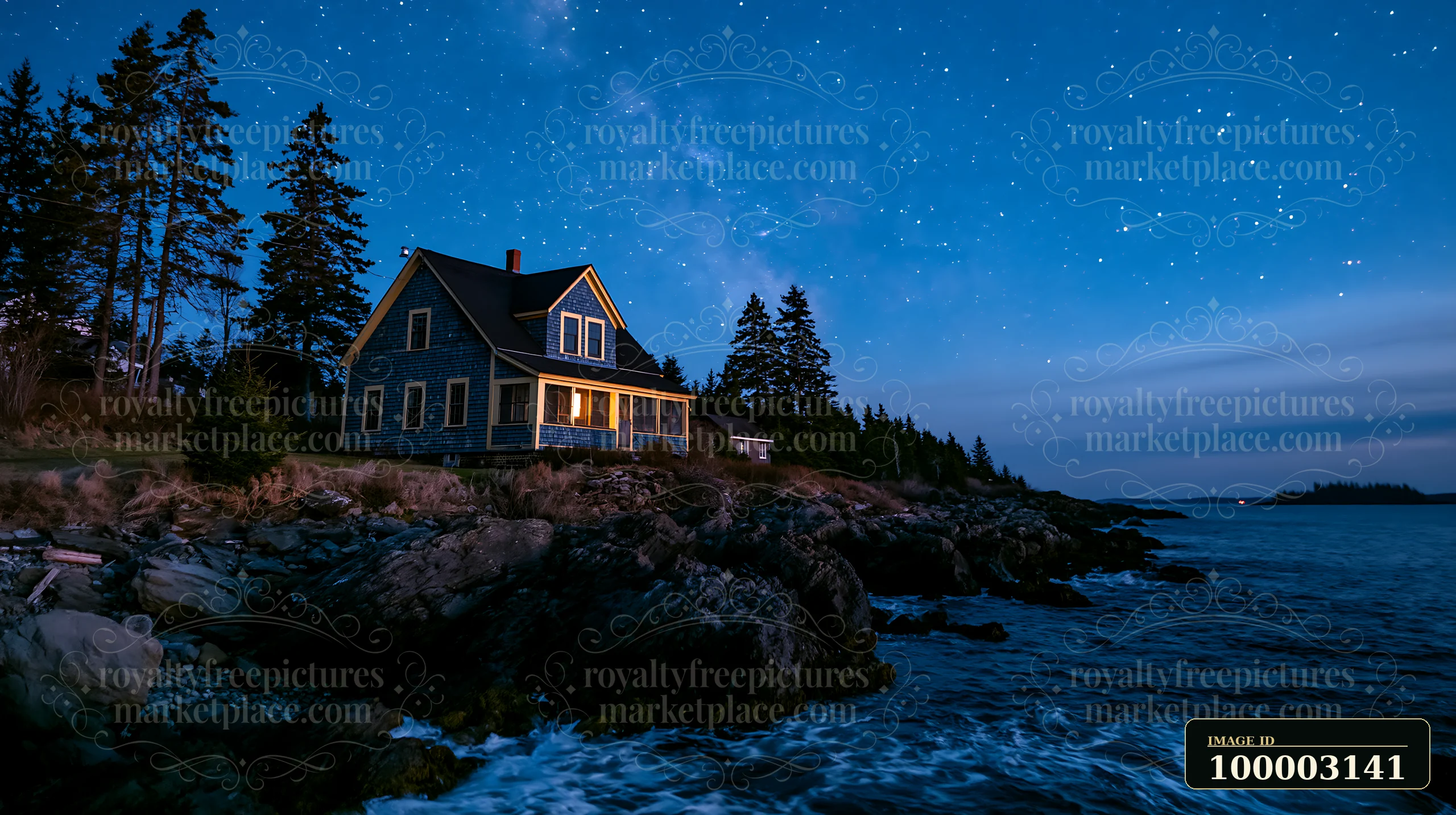 A house stands on the edge of a rocky coastline as the sky fills with stars at night.