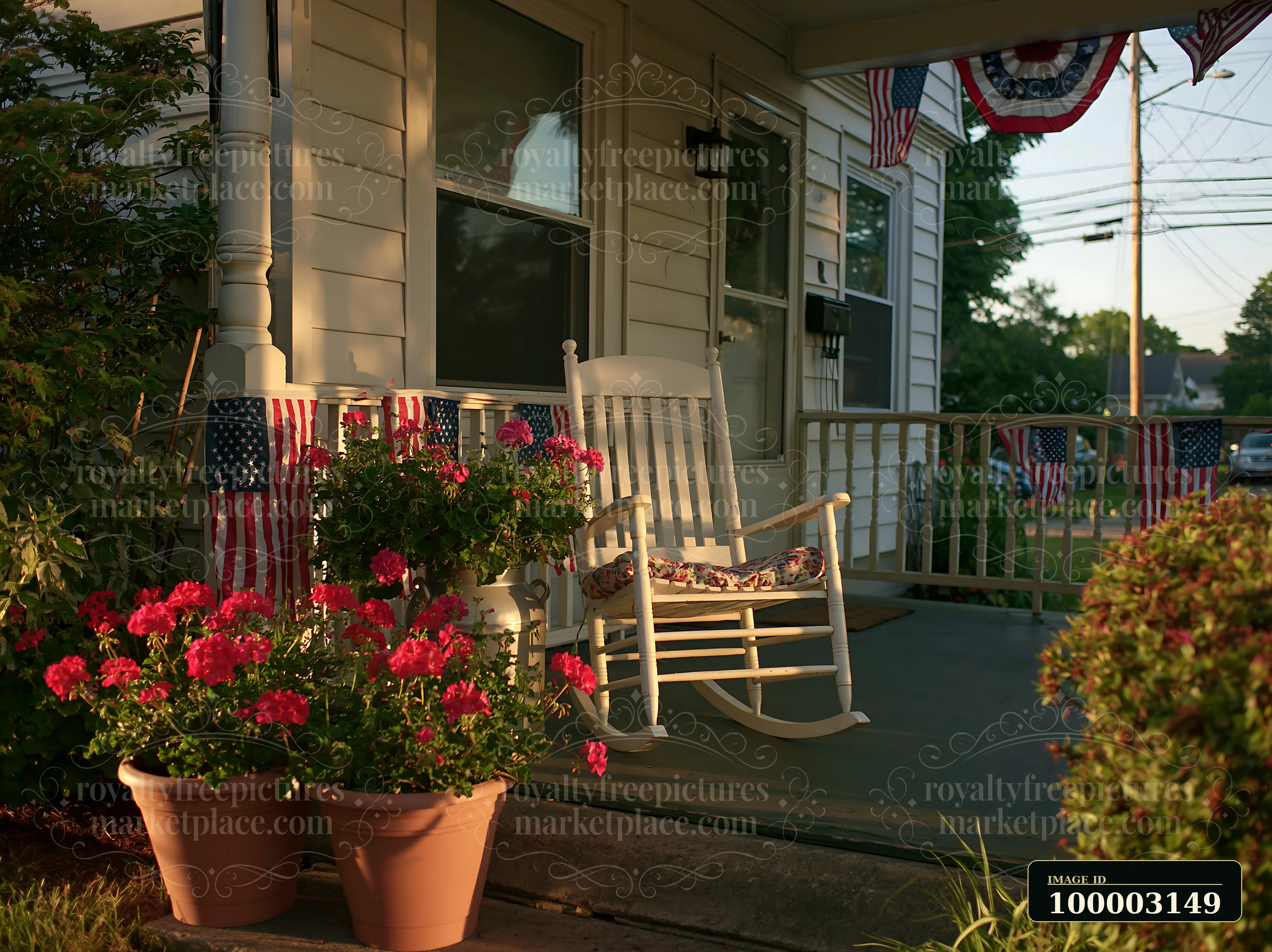 American flag decorations on porch are displayed alongside potted flowers and a rocking chair.
