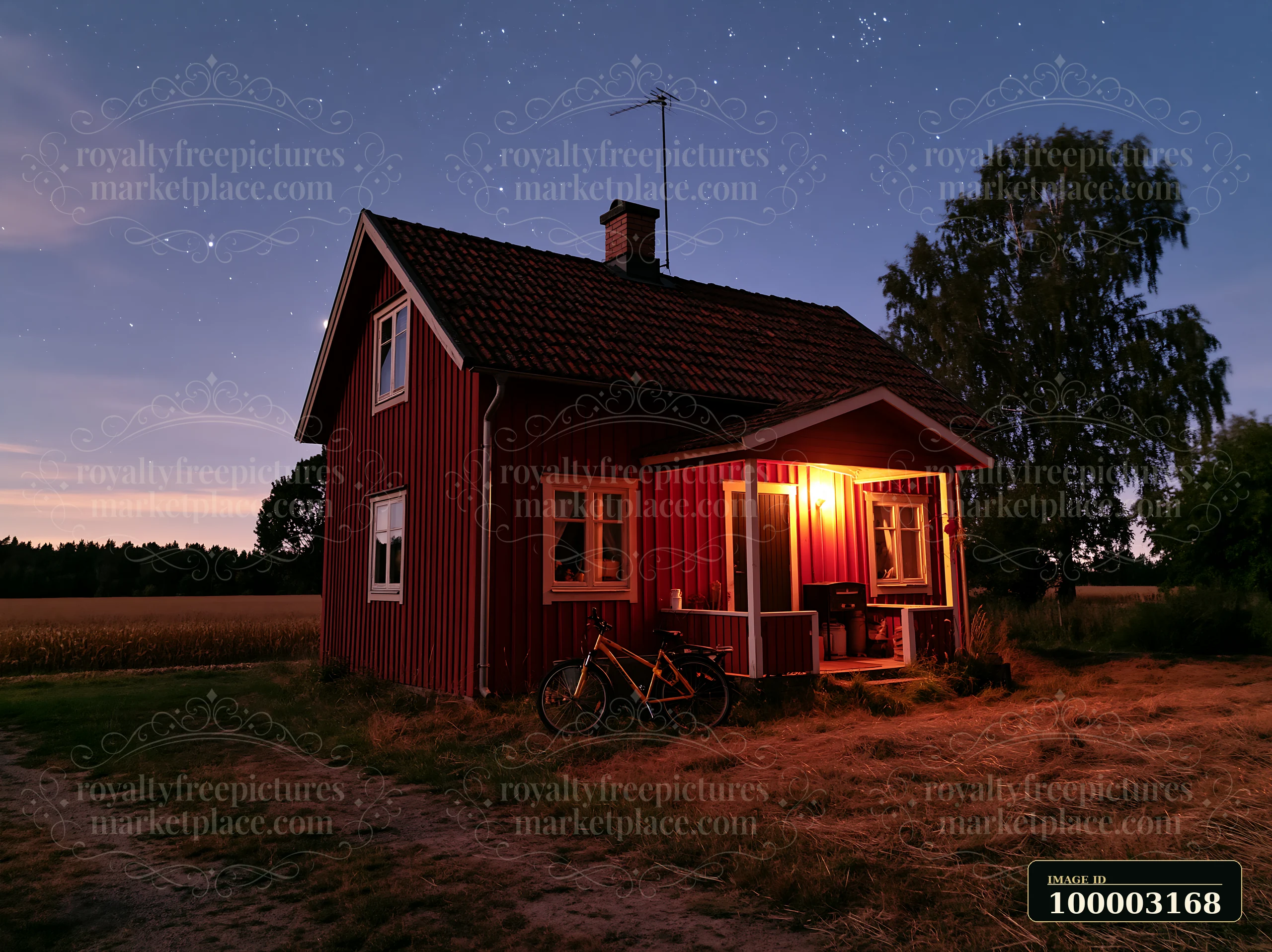 A small red house stands under a starry sky with warm light coming from the windows at night.