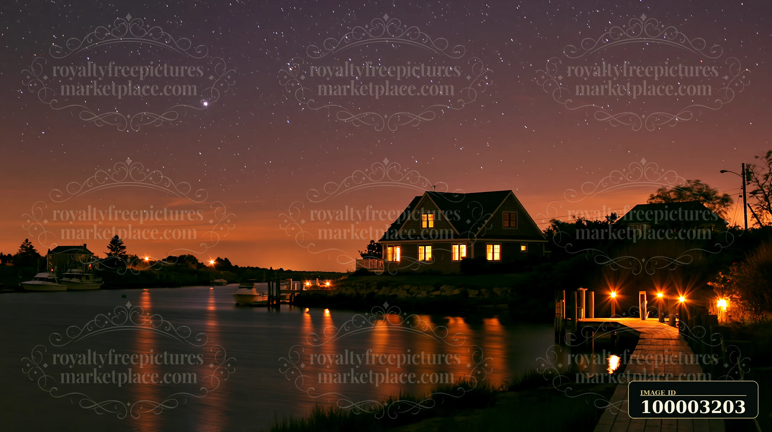 A coastal home sits by the water with a clear view of the ocean horizon under a starry sky.