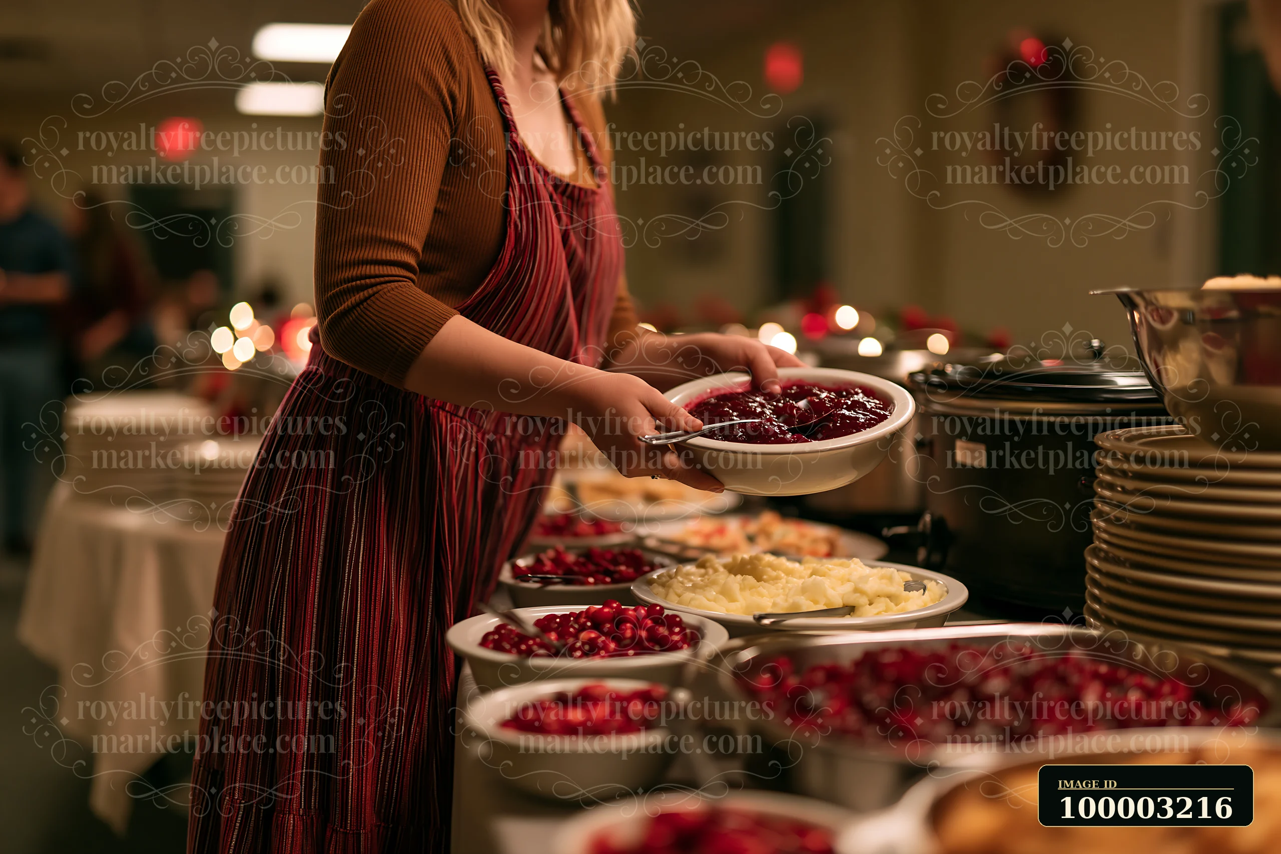 A person serves food from a table filled with different dishes during a holiday buffet dinner in a festive setting.