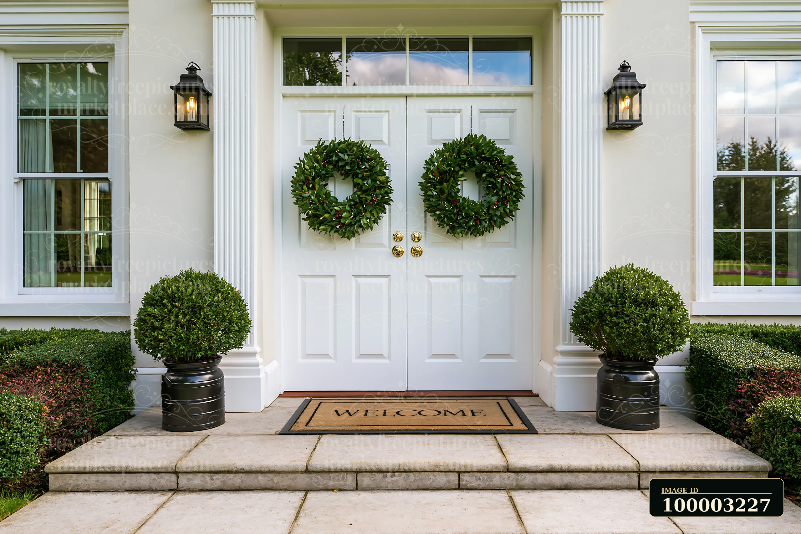 The front door with wreath and welcome doormat stands at a house entrance.