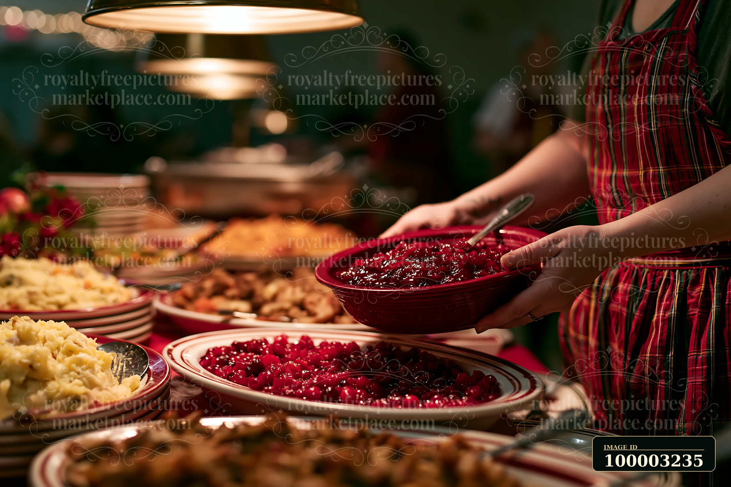 A woman serves cranberry sauce from a bowl during a holiday buffet dinner.