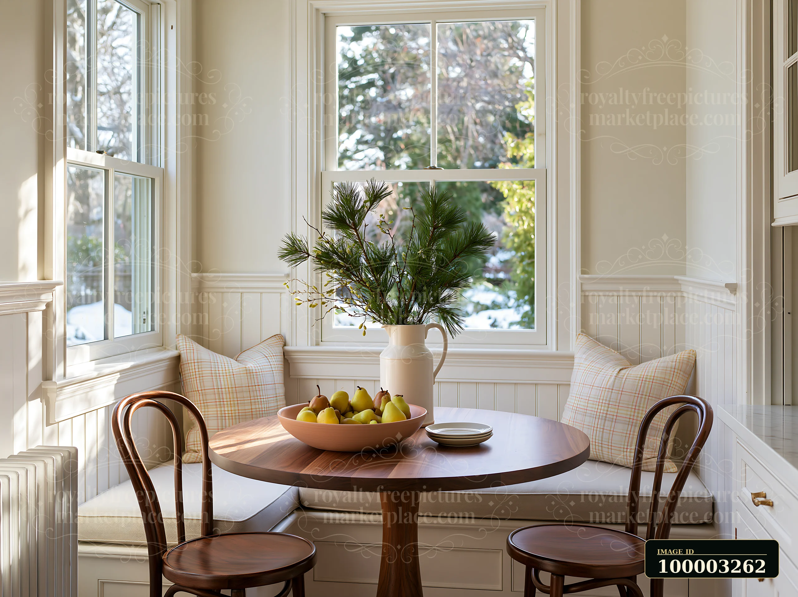 This elegant kitchen with nutcracker-free holiday decor showcases a round wooden table surrounded by two chairs.